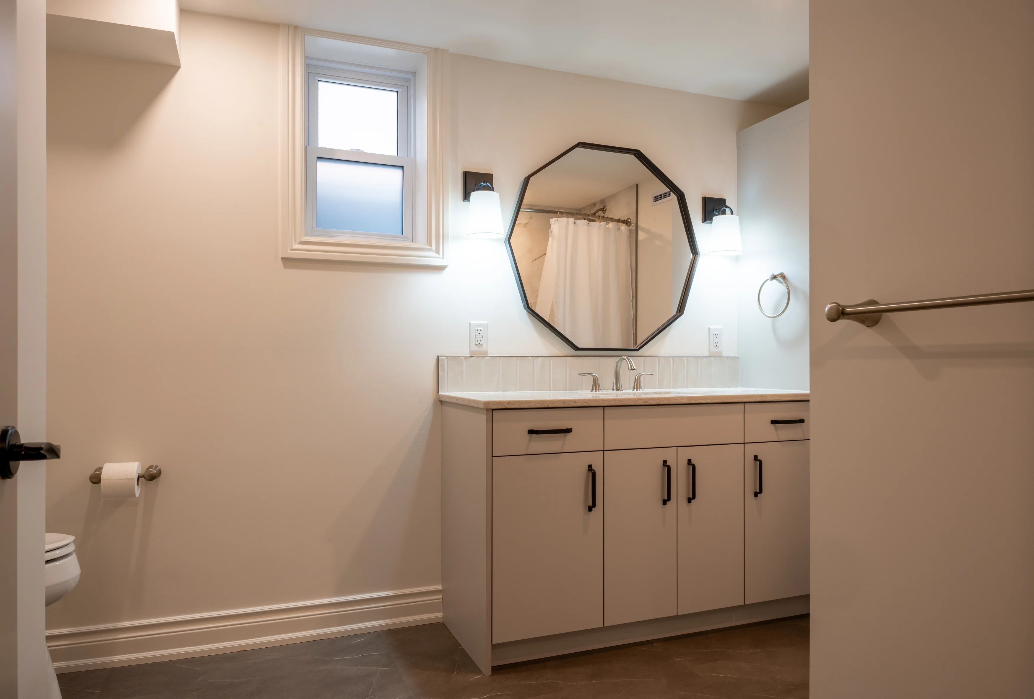 large bathroom space with sinks, mirrors, countertops, and cabinets