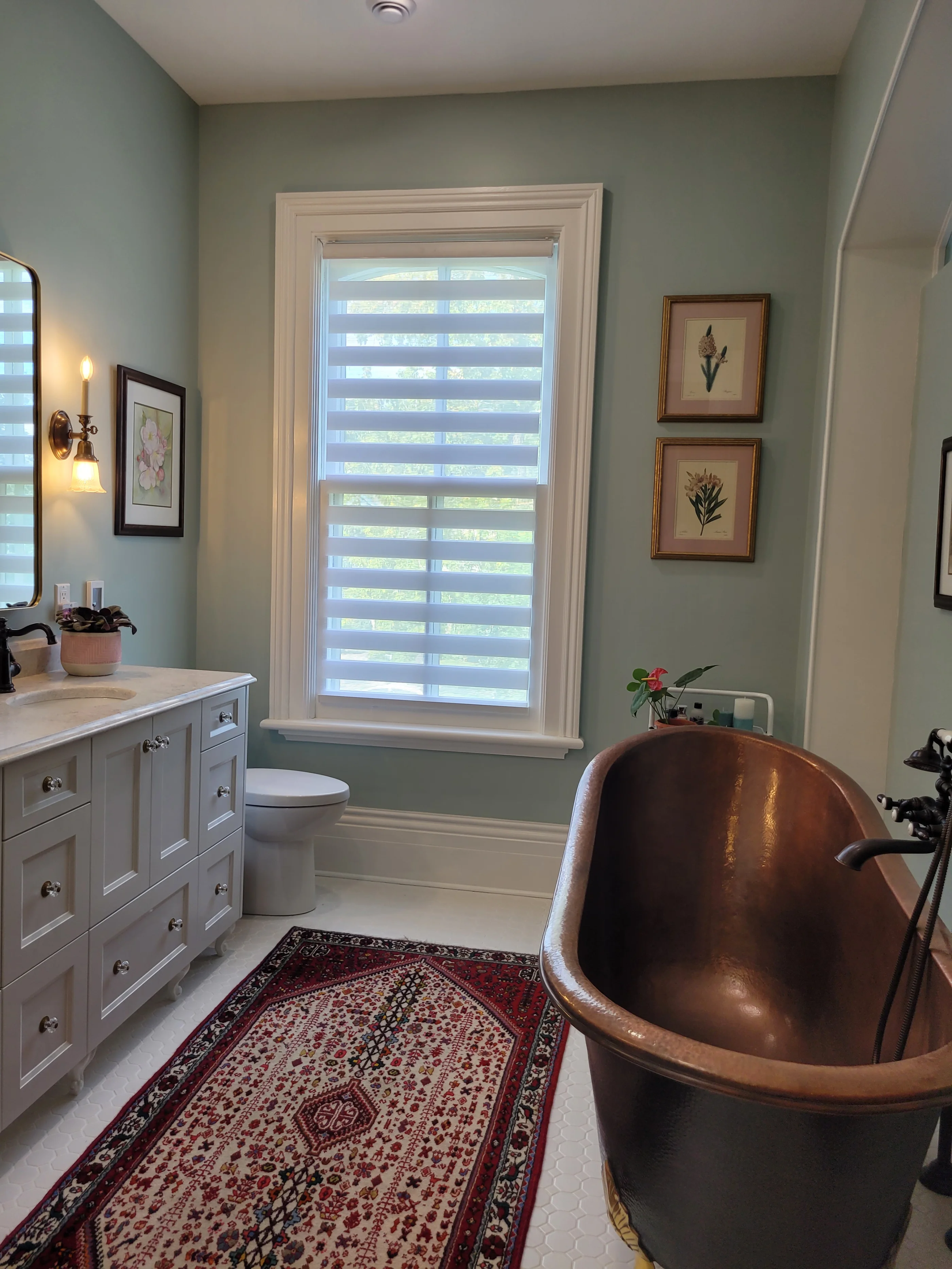 view of bathroom, with copper tub, facuets, and cabinets under a white sink