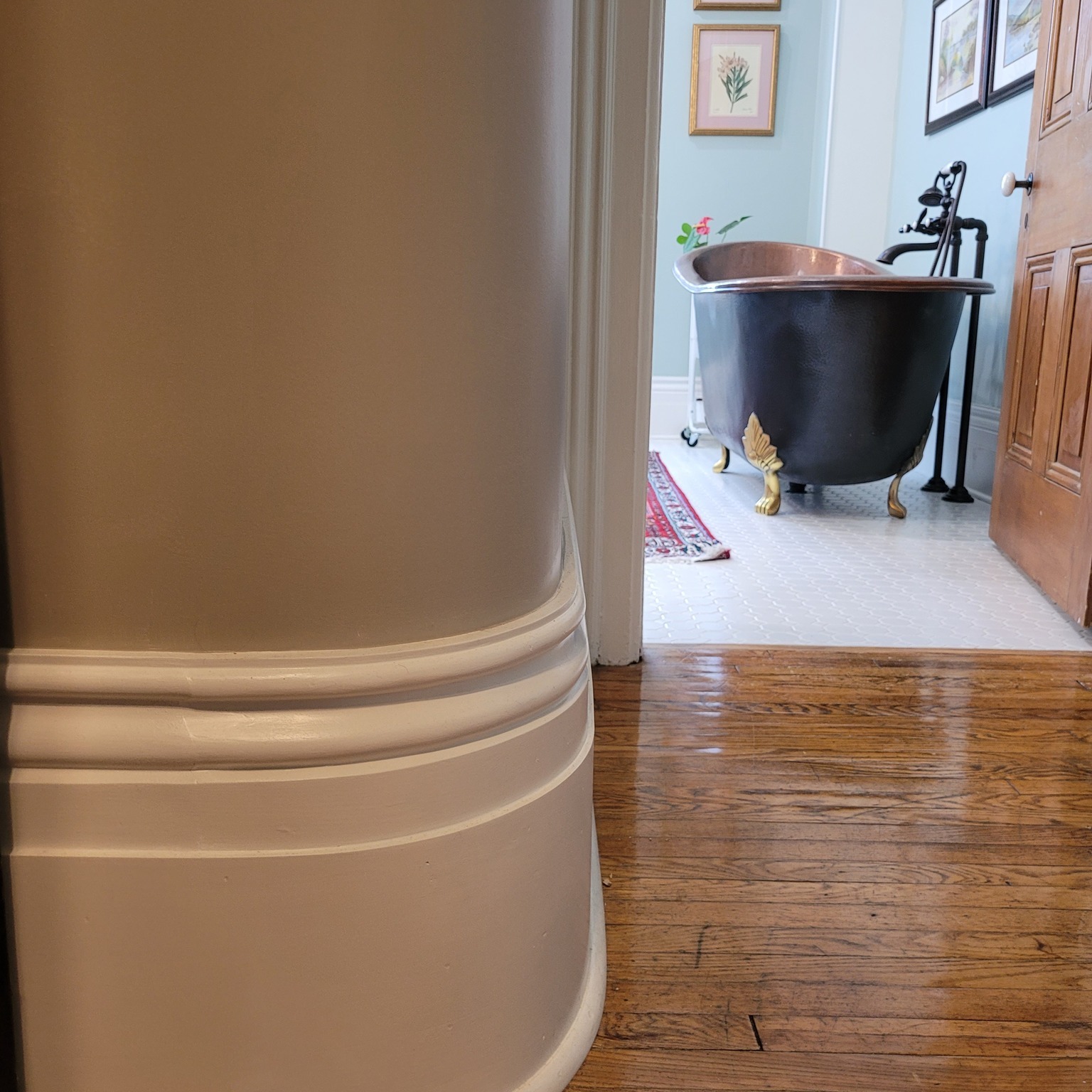 copper bathtub in bathroom, molding in white on walls