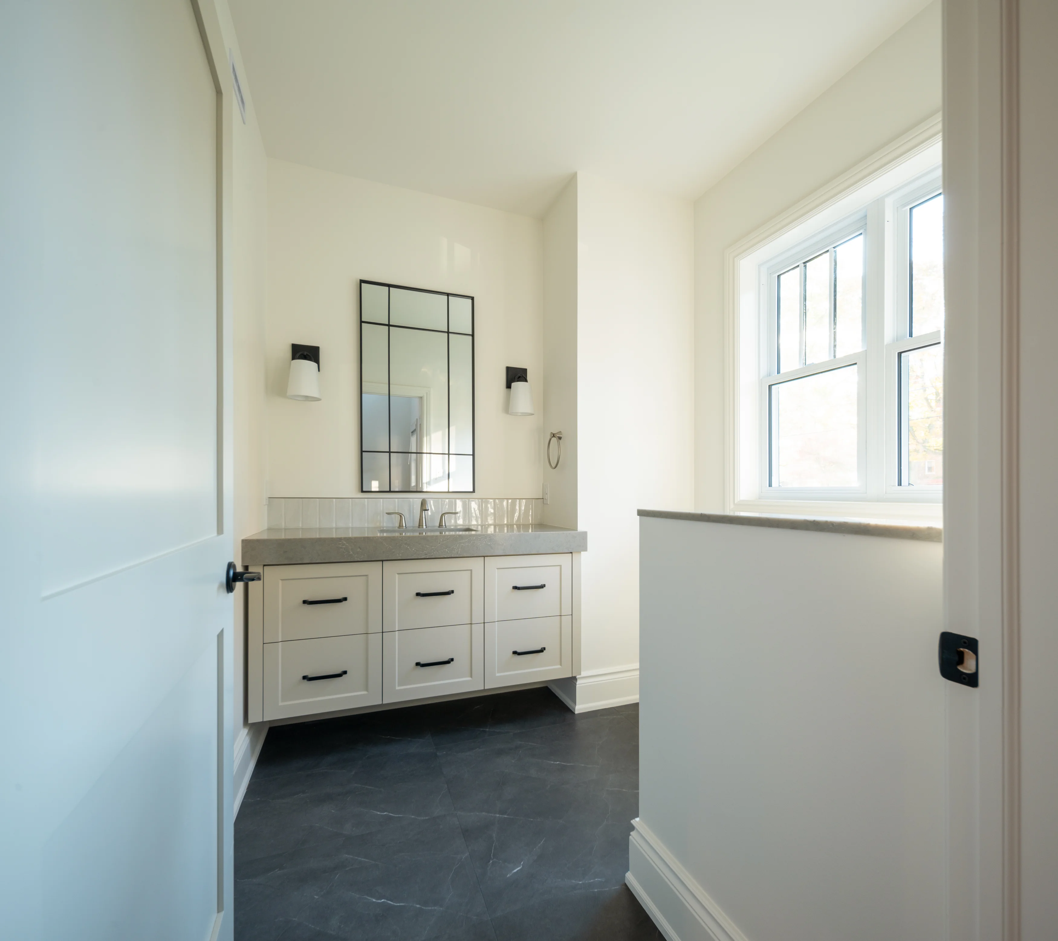 large bathroom space with toilet, countertops, cabinets, sinks, and mirror