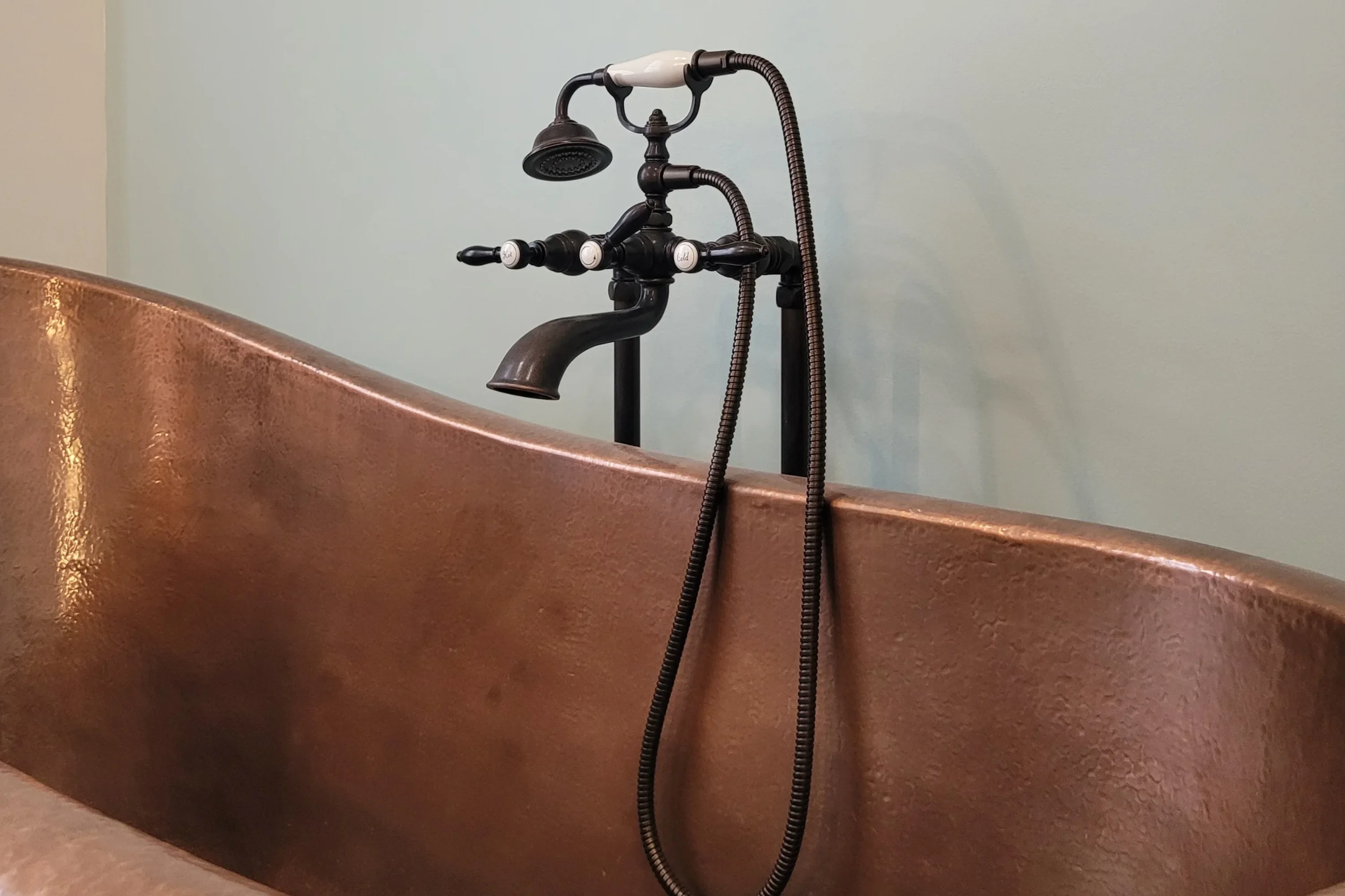 copper tub with old style faucets in black