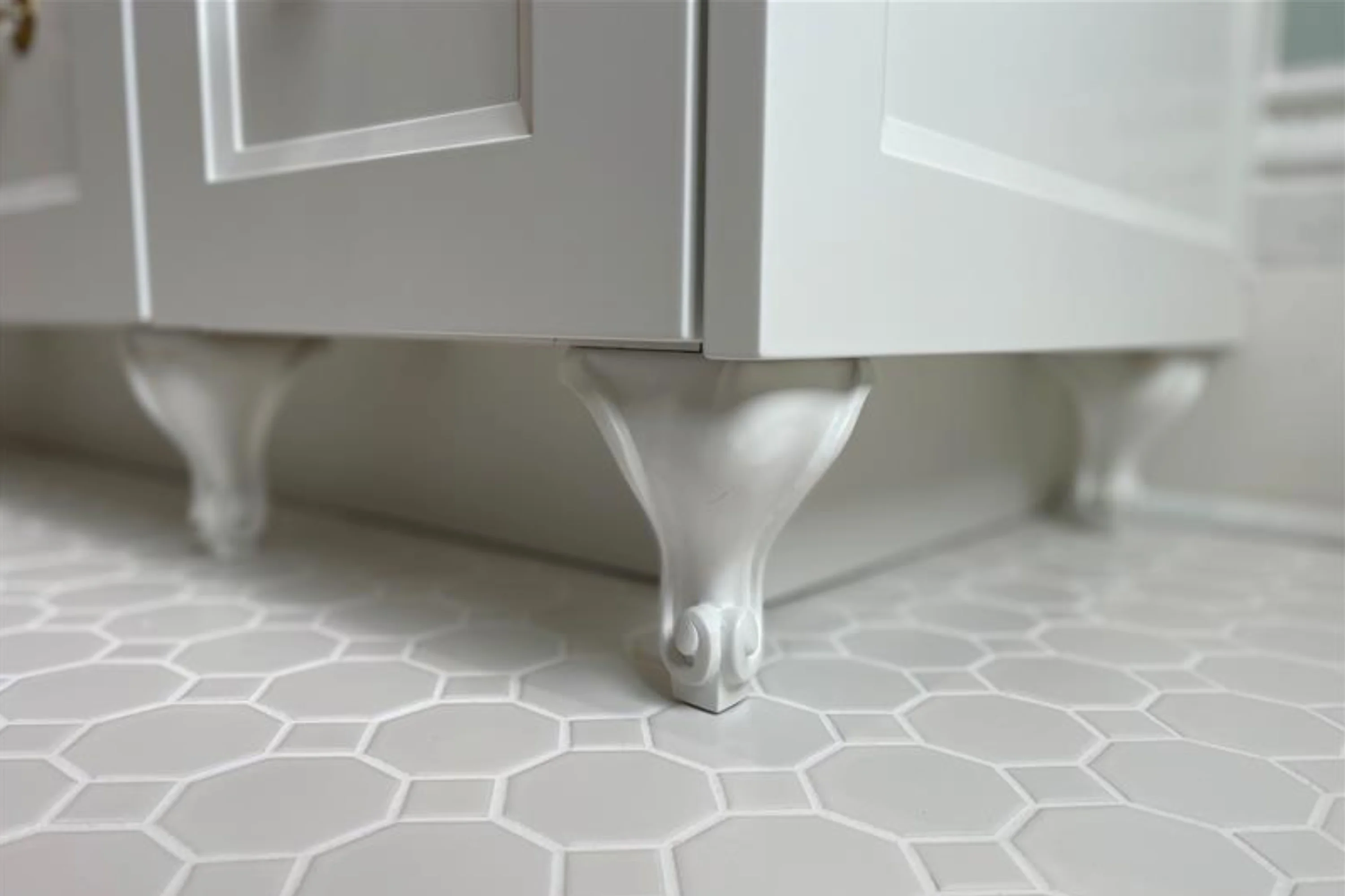carved feet at bottom of white cabinet