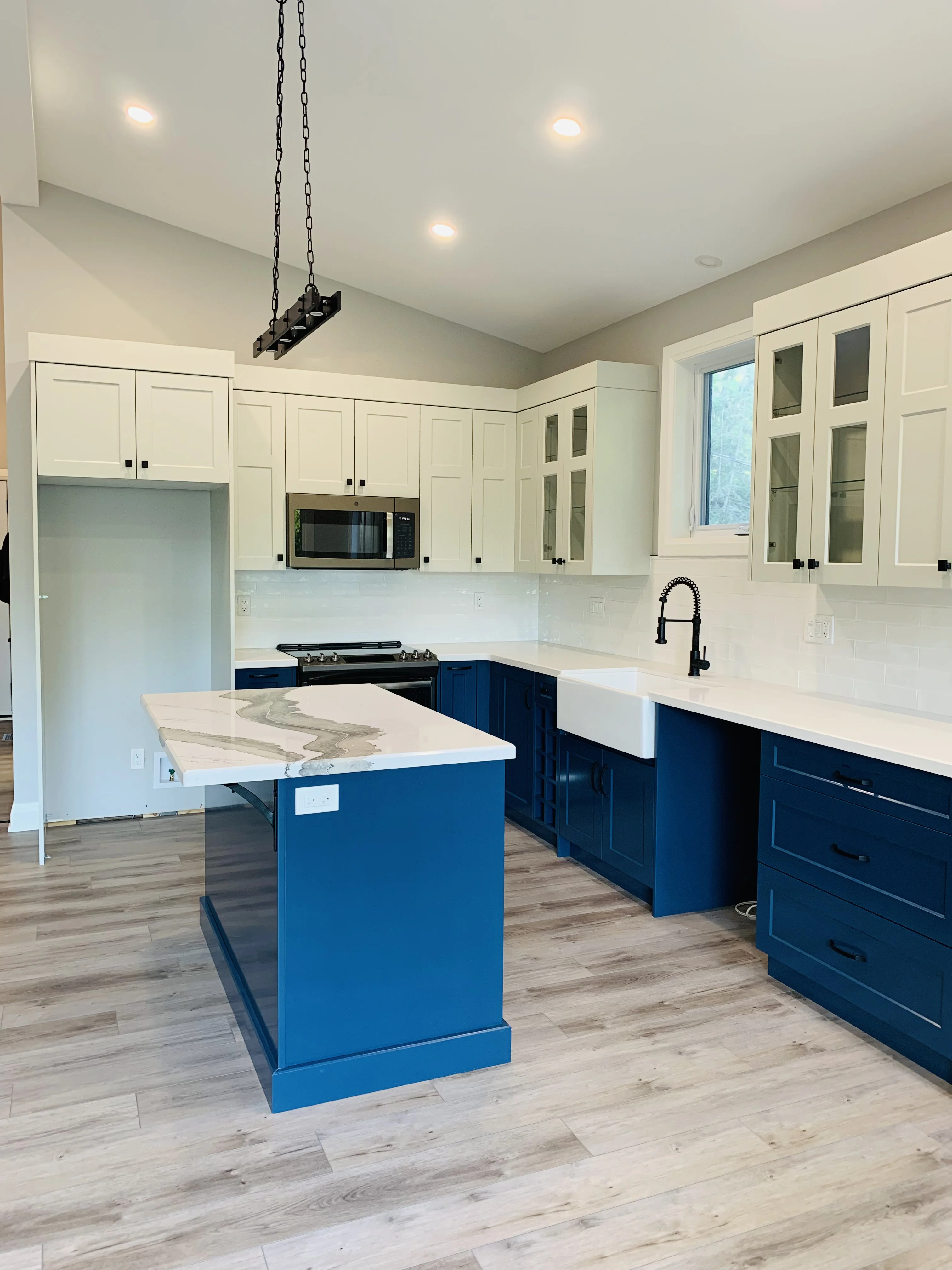 kitchen with marble counters, blue cabinets, white cupboards