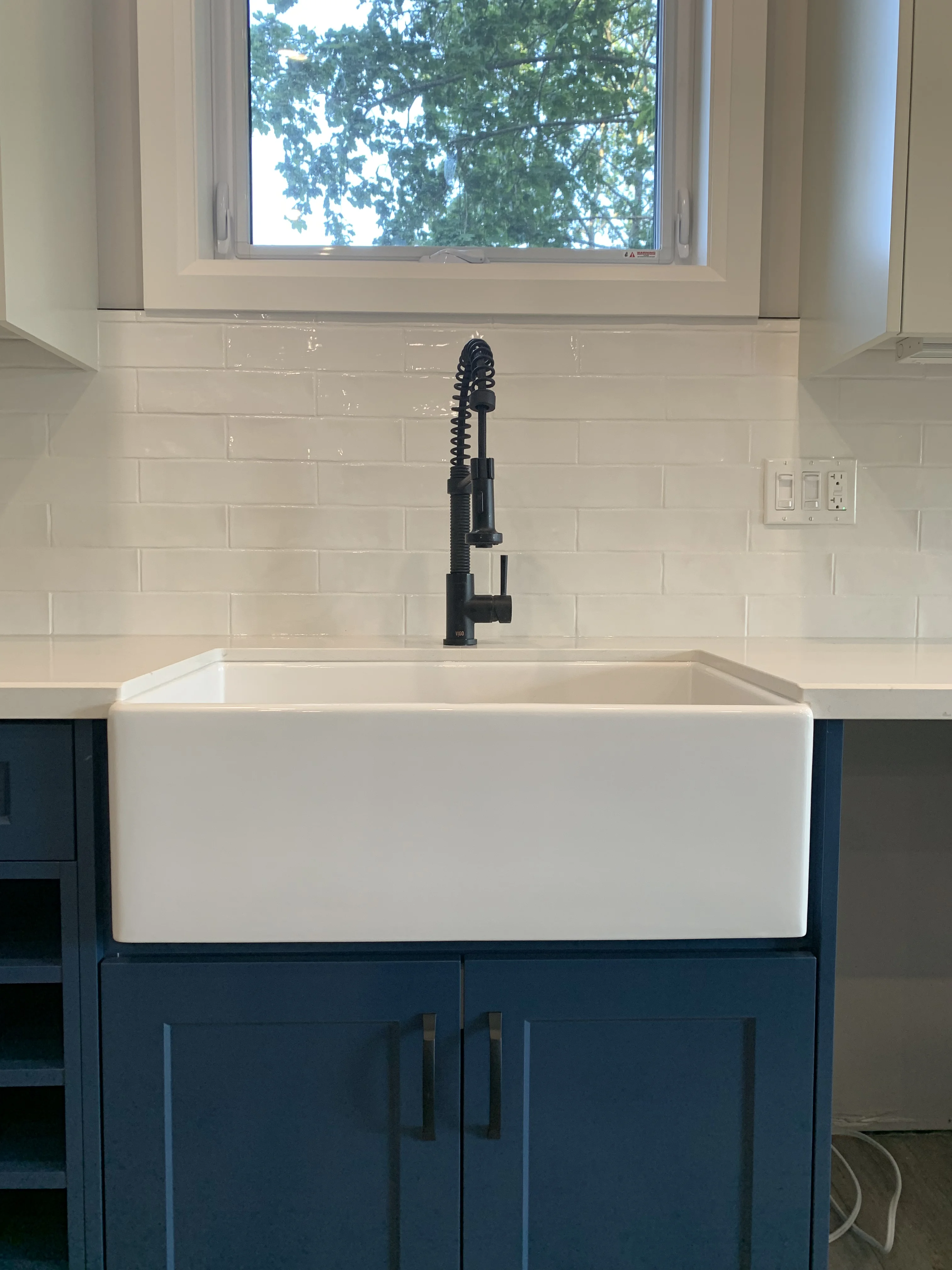 white sink over blue cabinets in white and blue kitchen