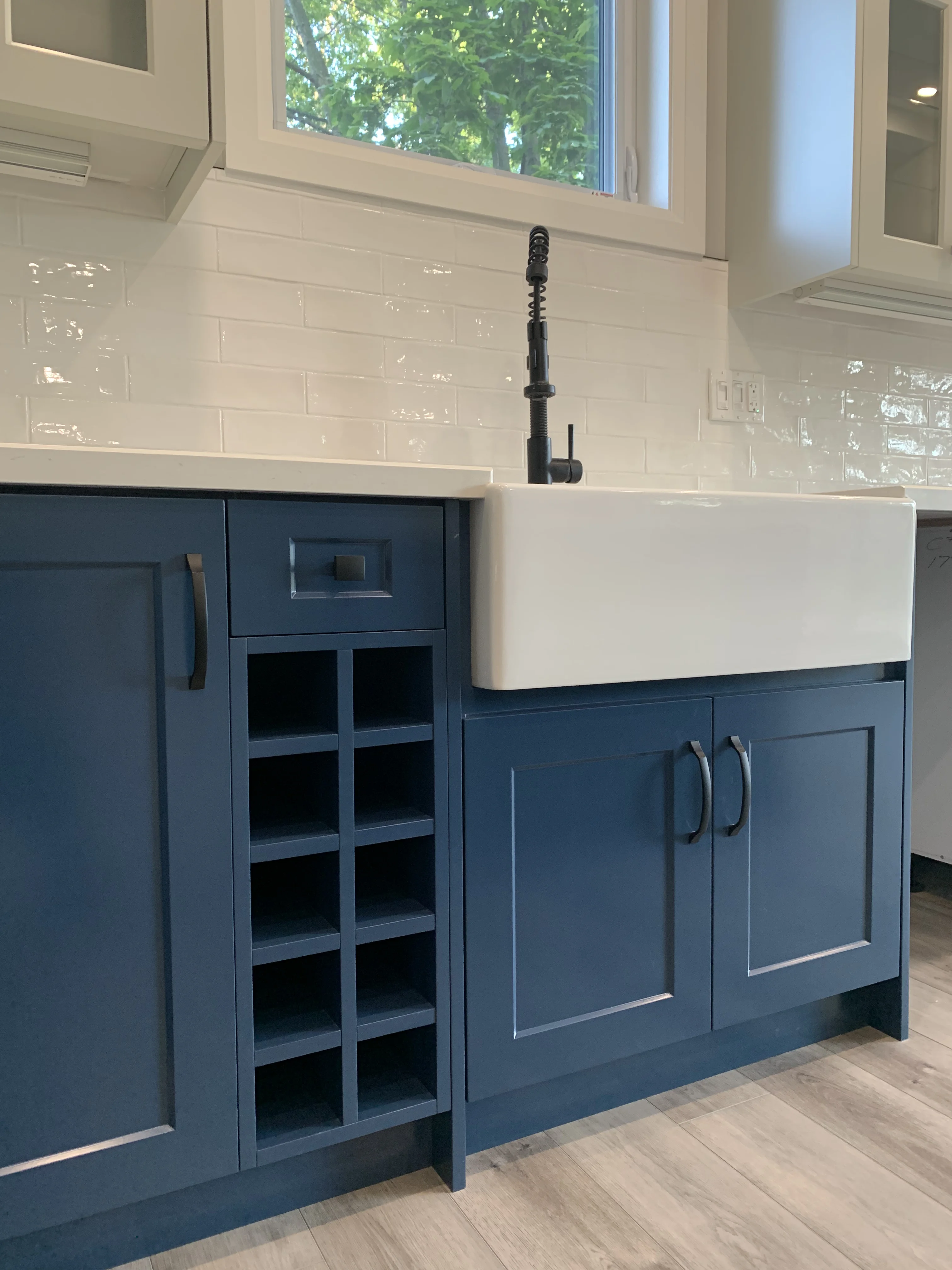 kitchen space with blue lower cabinets beneath a white sink