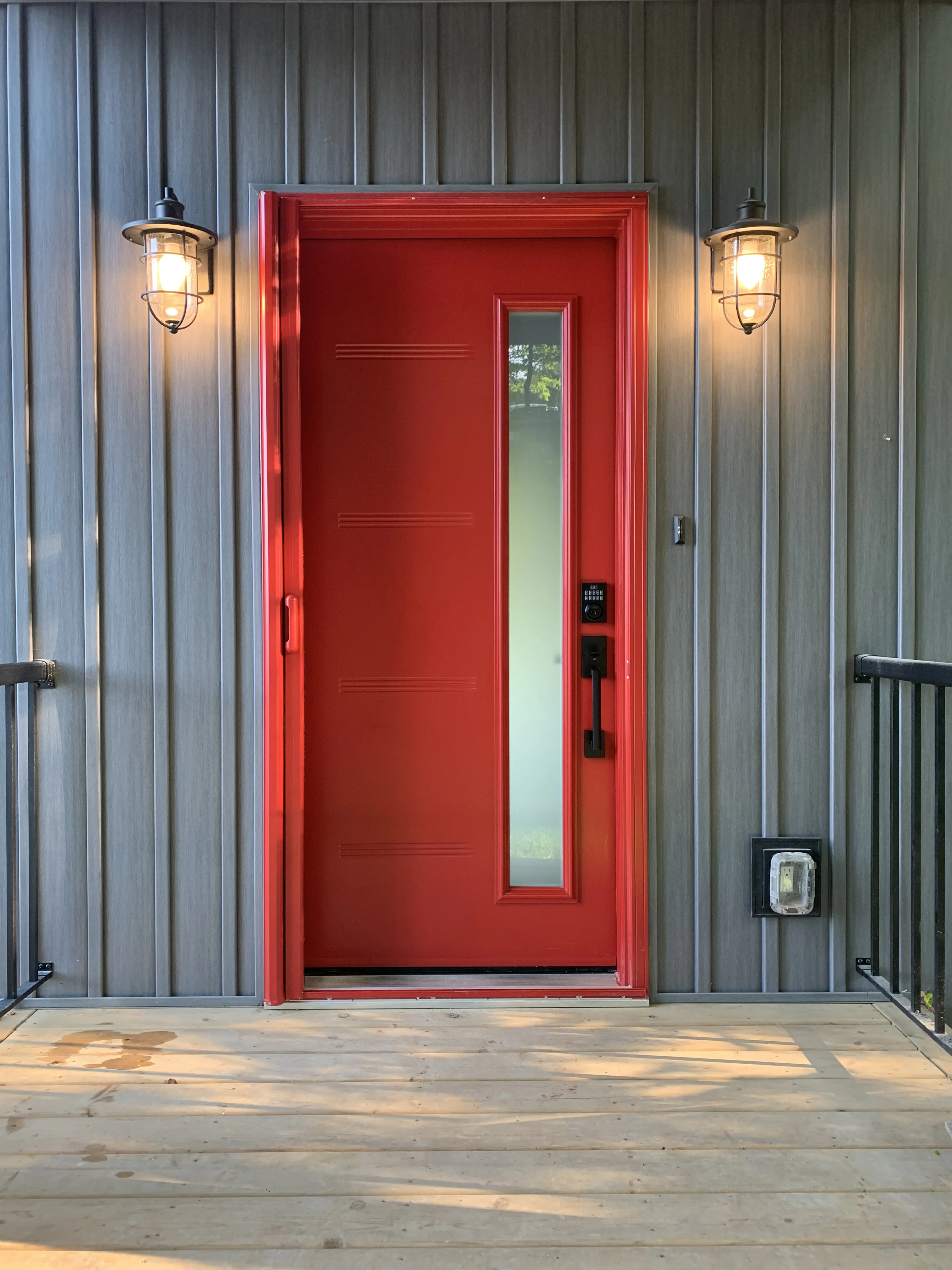 red front door with grey siding beside it