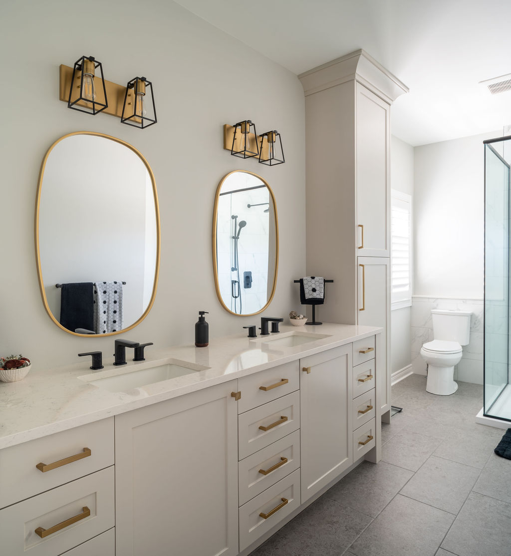 a bright white bathroom with large mirrors and counters