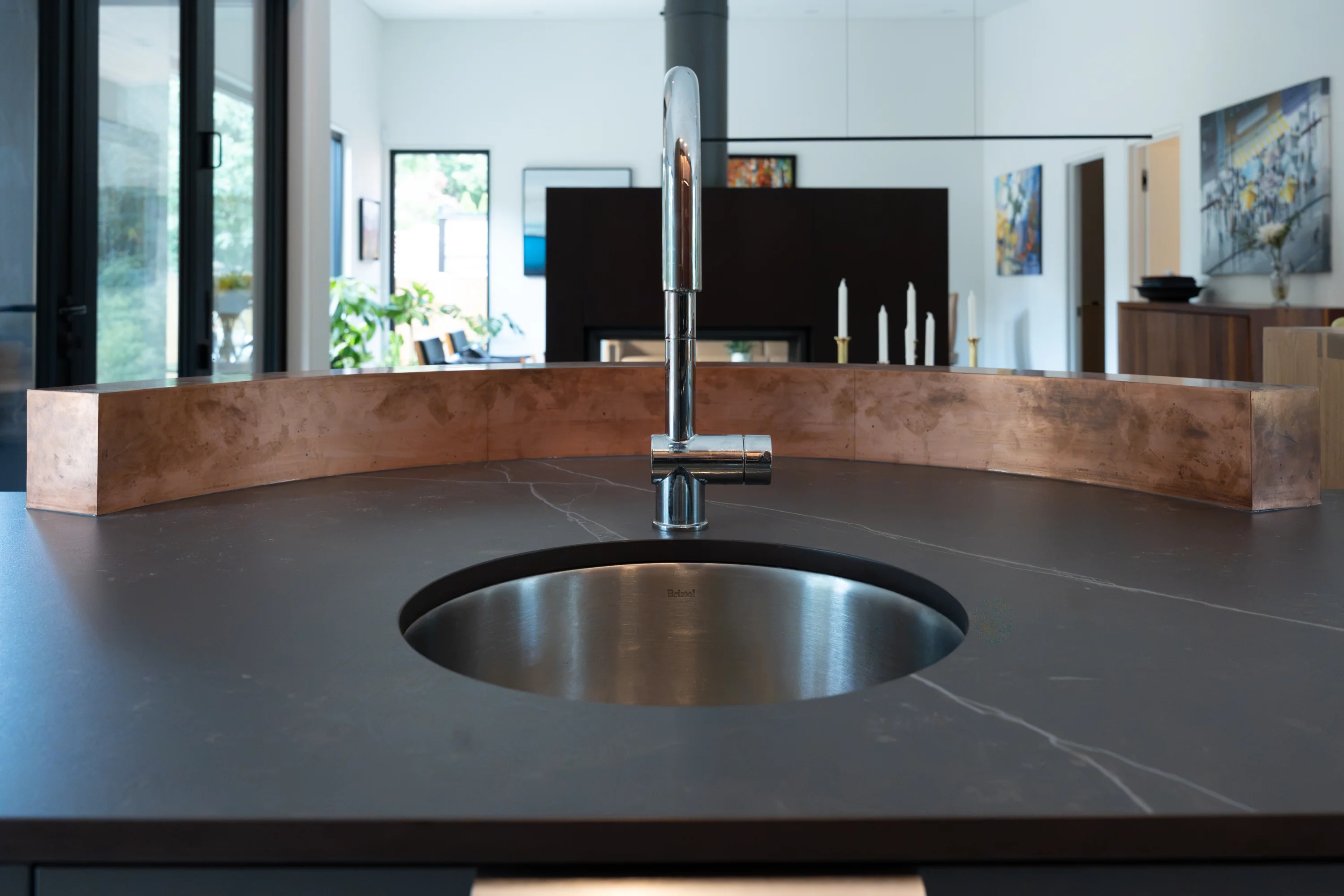kitchen sink with round basin and silver faucet