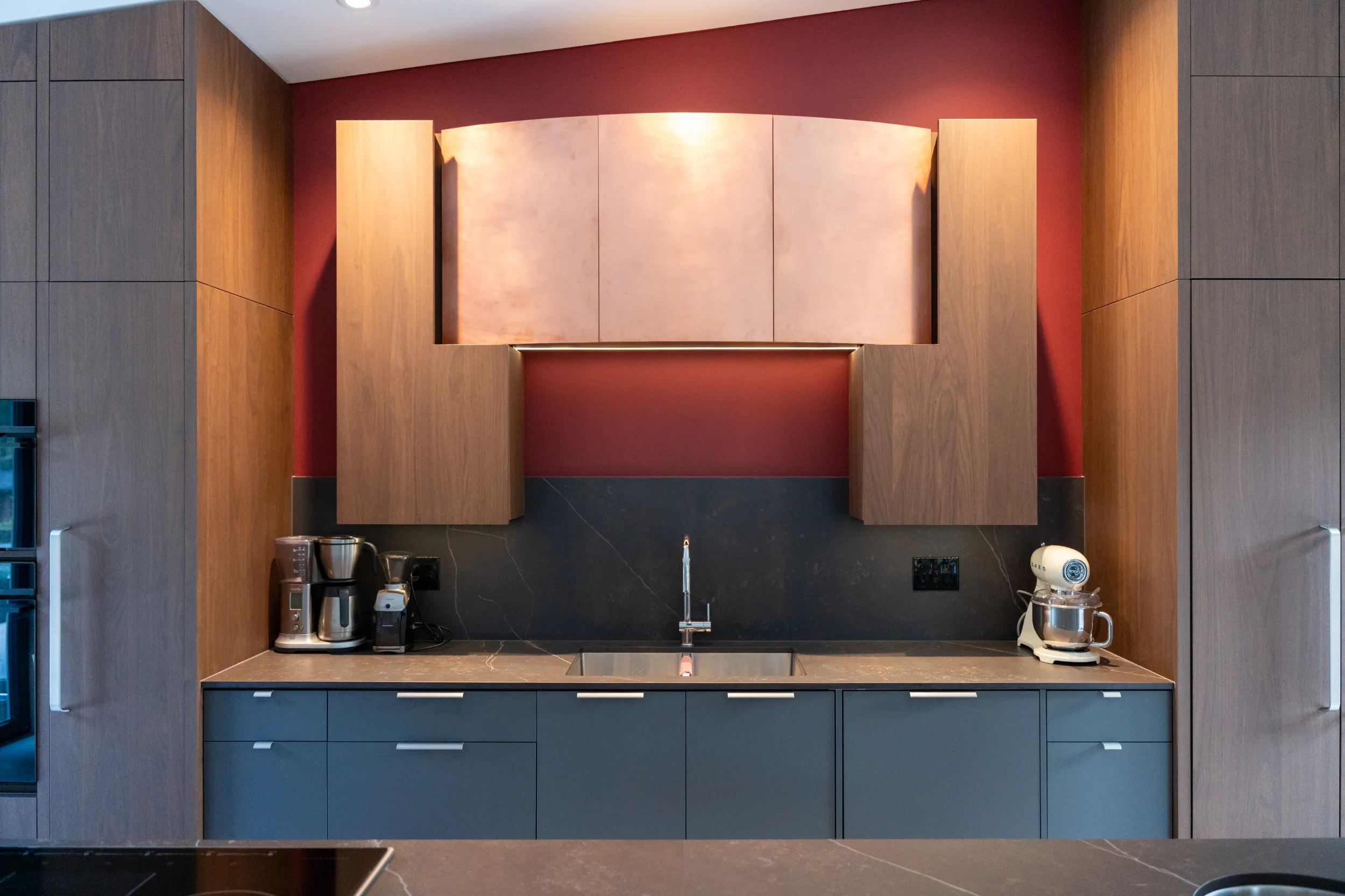 cabinets over a kitchen counter with faucet and appliances