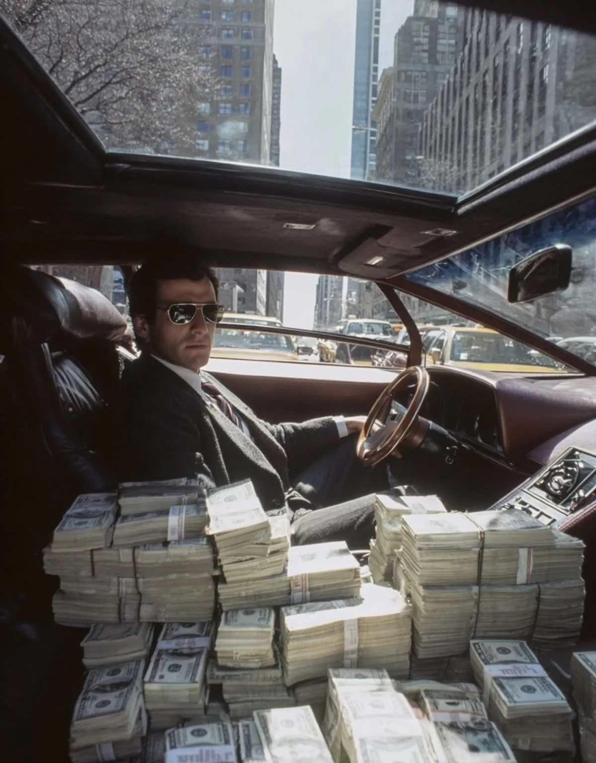 Man in een auto vol stapels bankbiljetten