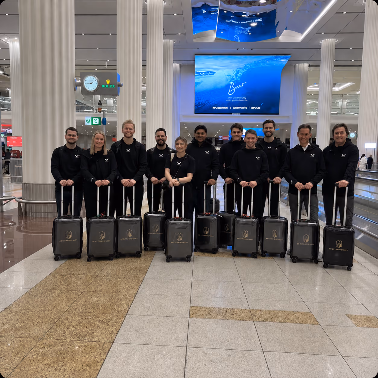 Groep mensen in uniformen met rolkoffers op een luchthaven.