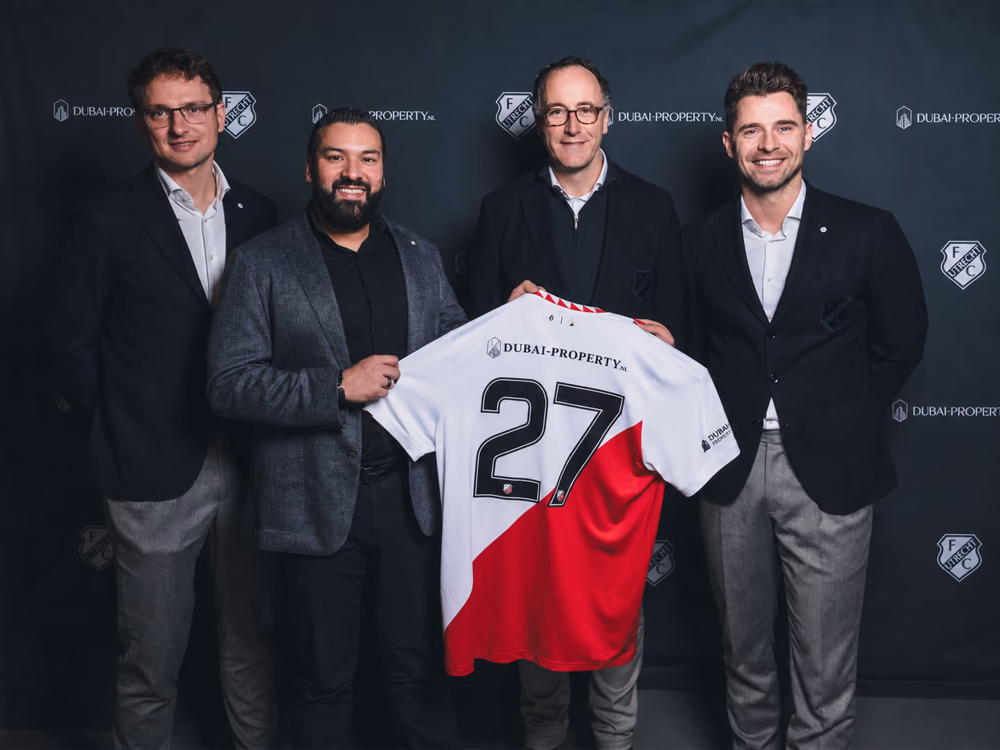 Groep mensen presenteert voetbalsponsoringsdeal met shirt van FC Utrecht.