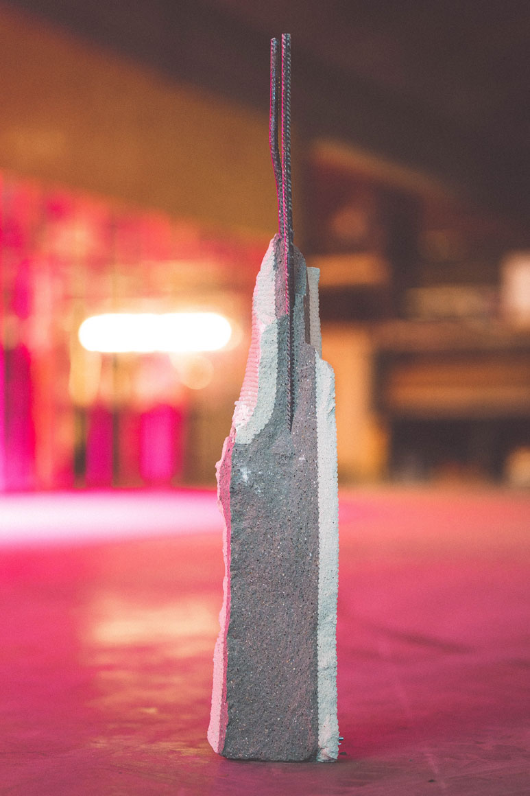 Cross-section of a hybrid concrete structure showing a 3D printed outer shell, a cast concrete core, and integrated steel reinforcement rebar
