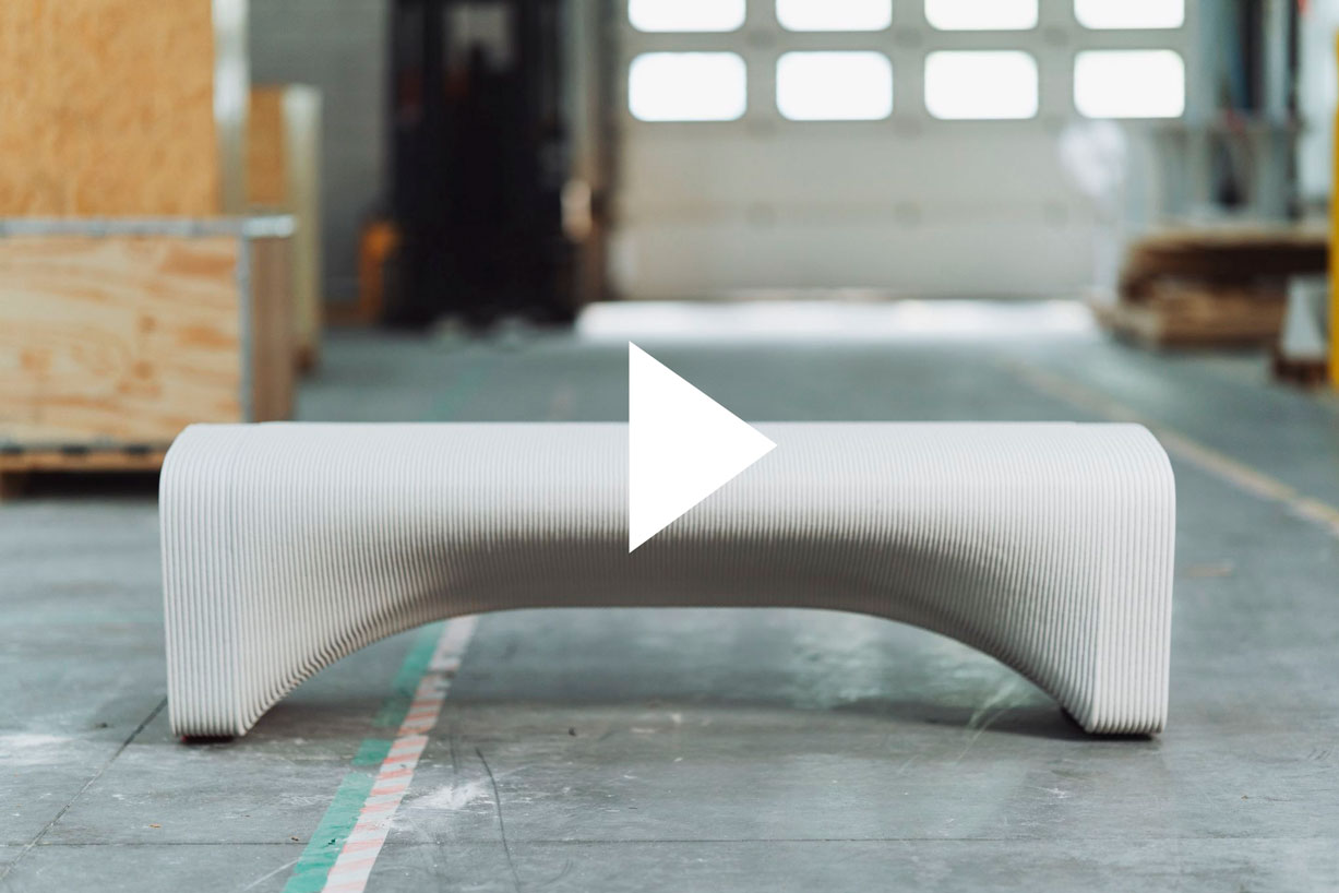 3D concrete printing creates curved, ribbed architectural bench in industrial space