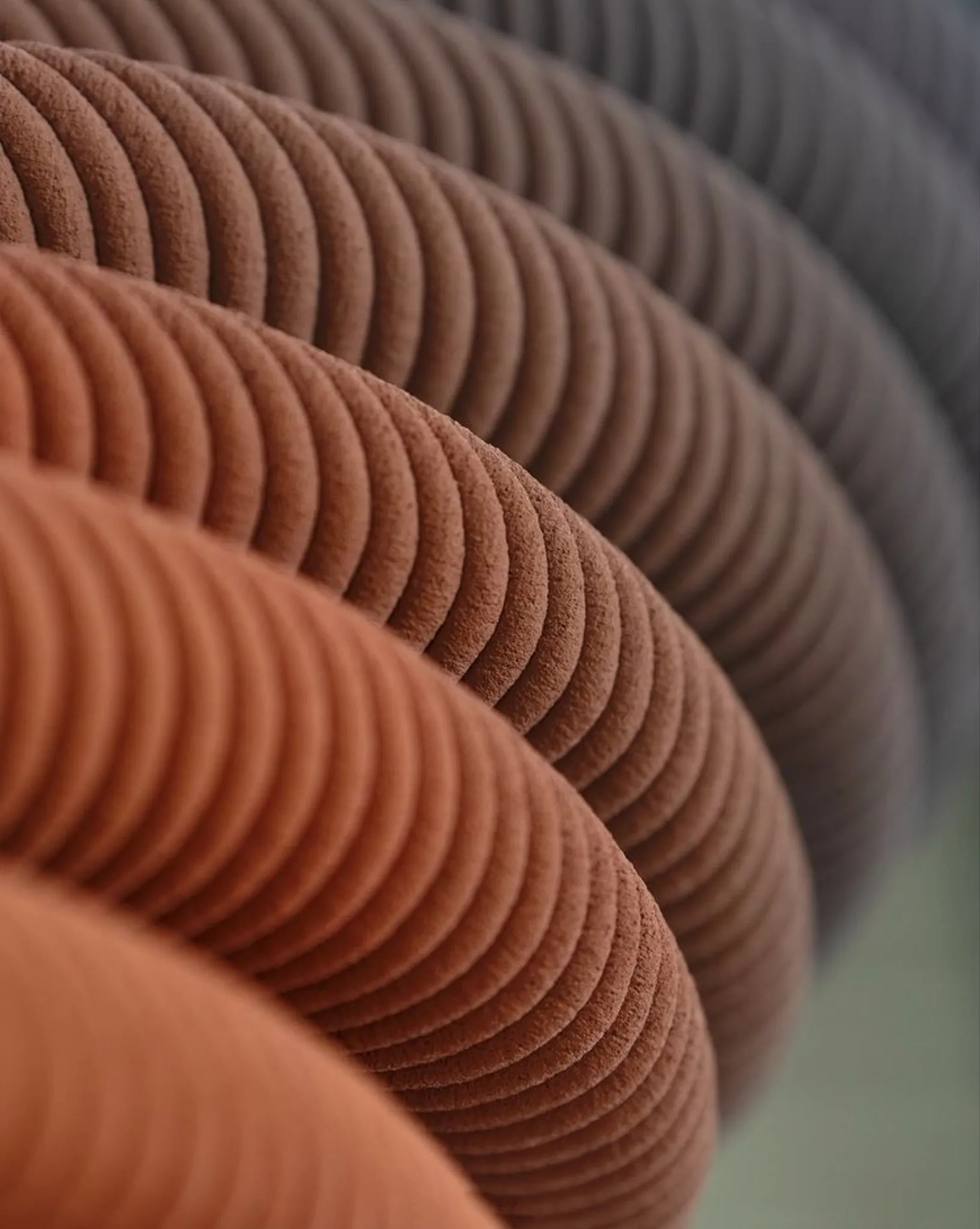 3D concrete printing revealing layered curved texture in warm brown tones