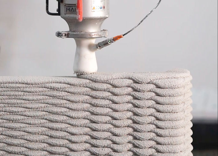 3D printer creating textured concrete layer with robotic extrusion nozzle