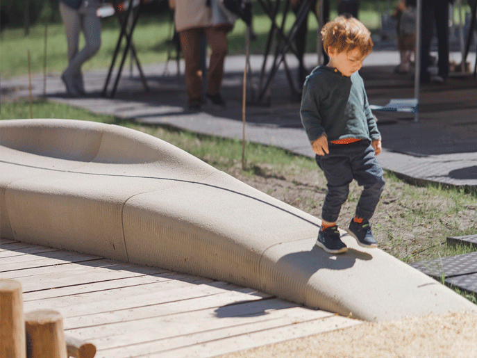 3D concrete printing creates smooth curved urban bench with child exploring