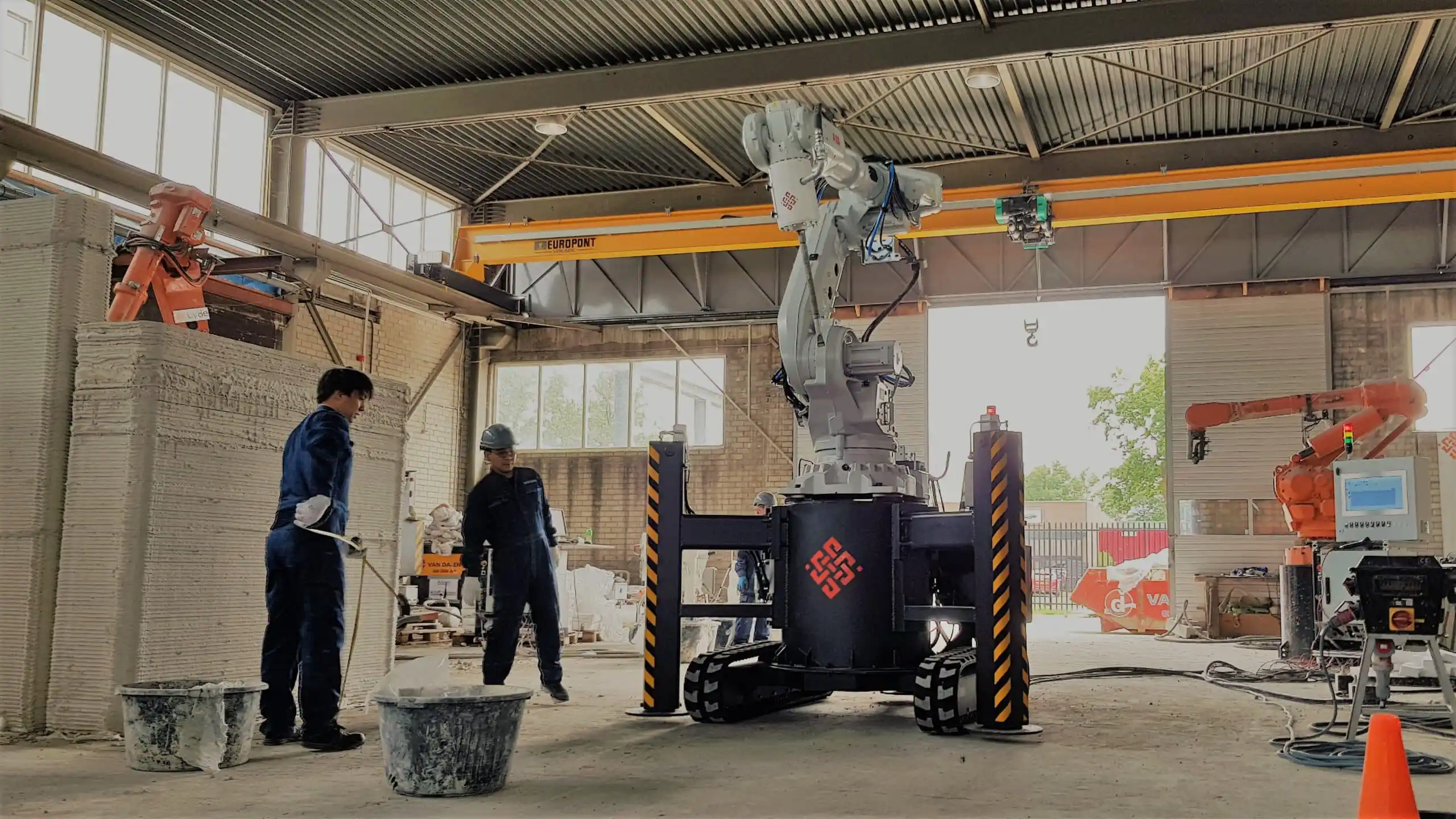 3D concrete printing robot in industrial facility with workers