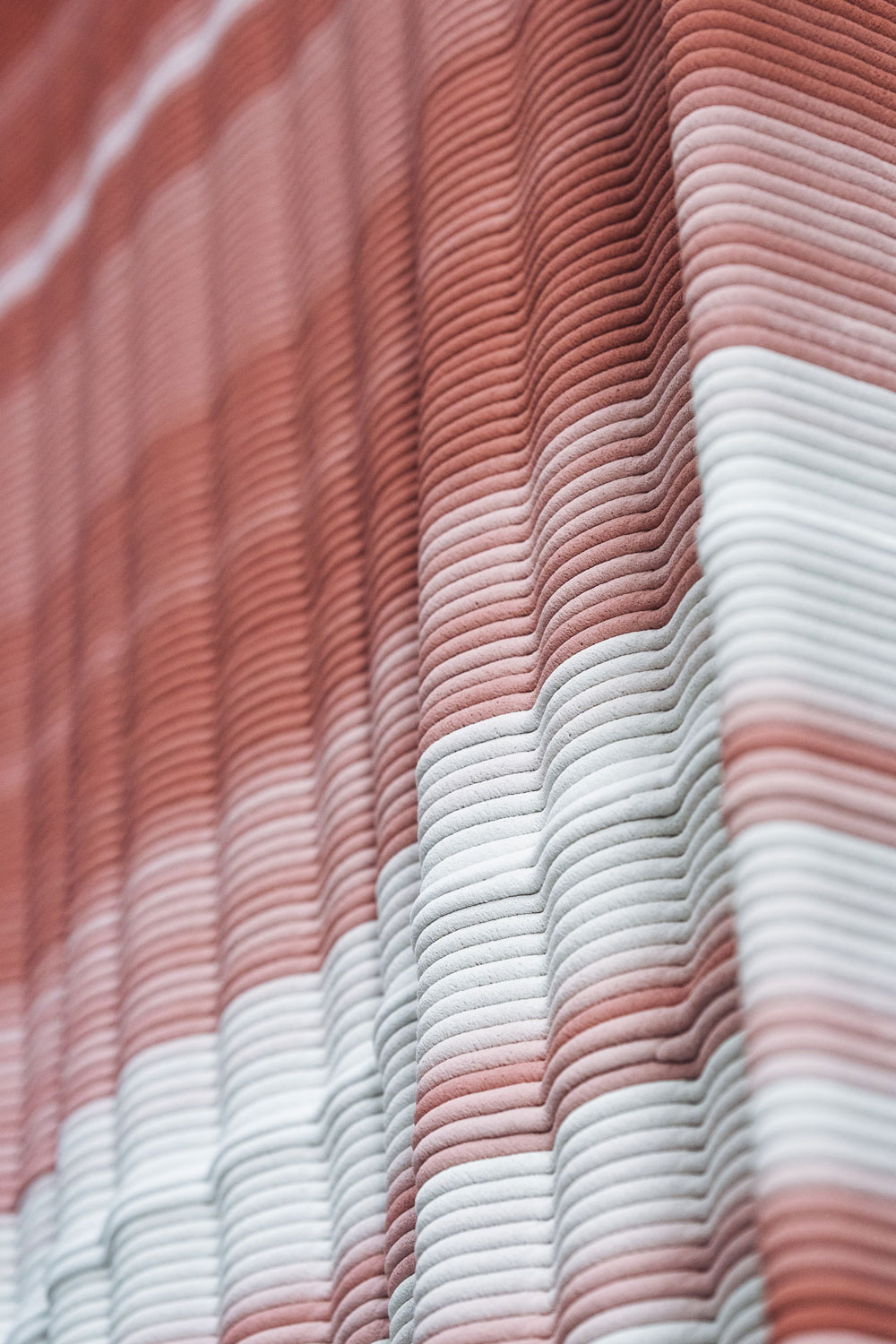 3D concrete printing creates wavy texture in soft pink and white gradient