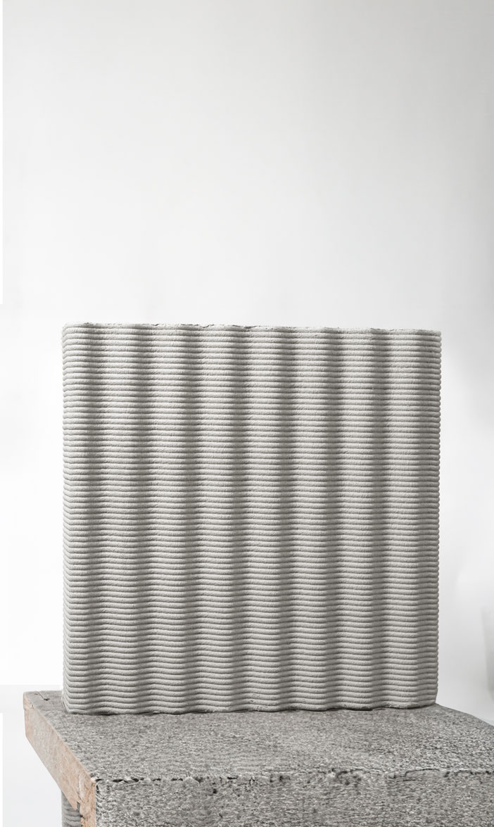 3D printed concrete block with horizontal ribbed texture on surface