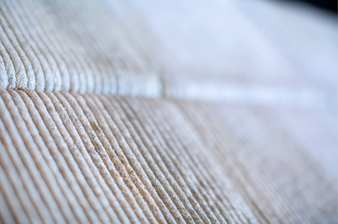Close-up of textured 3D concrete printing with layered, precise ridges
