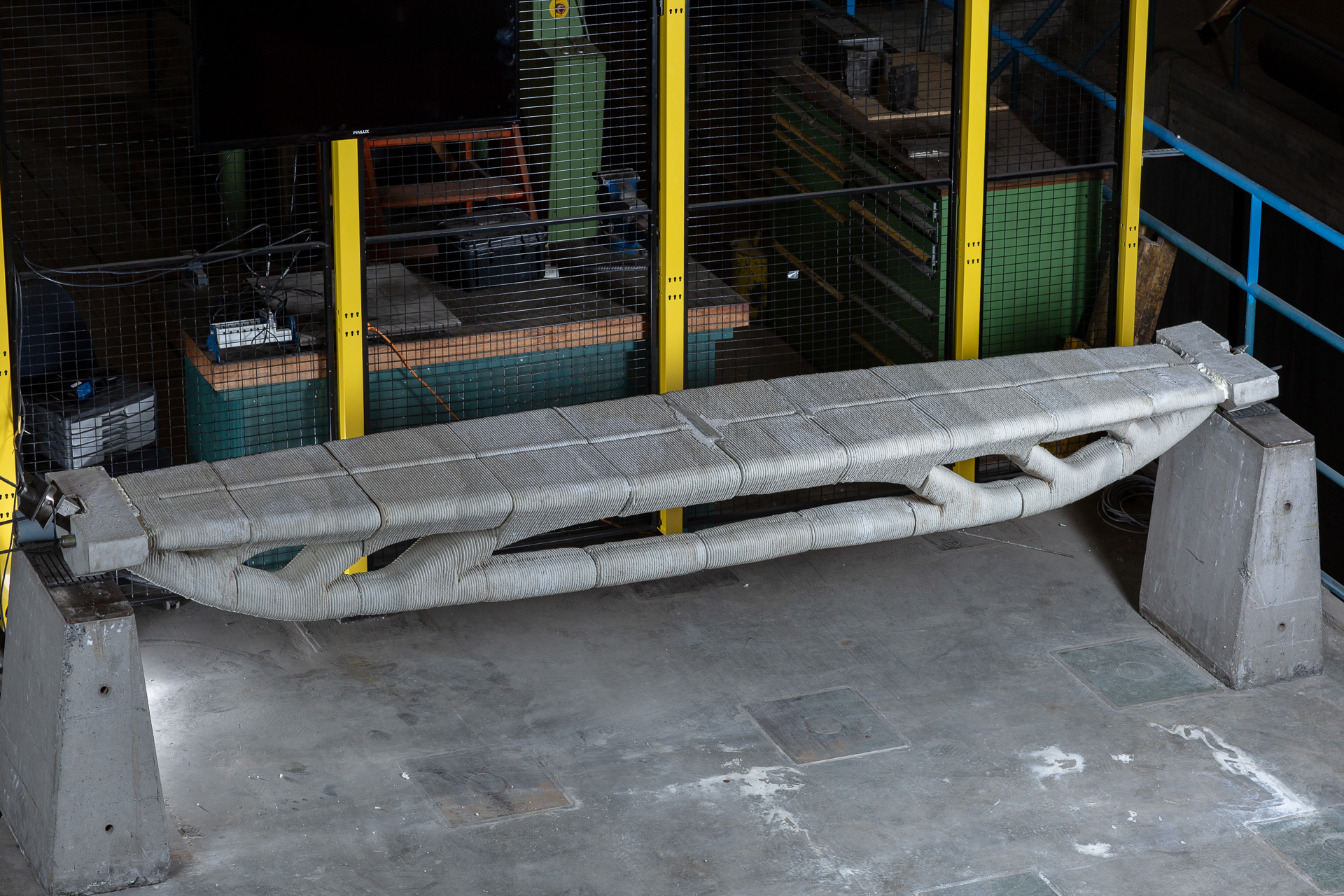 3D printed concrete beam prototype suspended on industrial concrete supports
