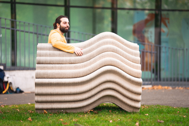 3D printed concrete wave-like bench with undulating organic design outdoors