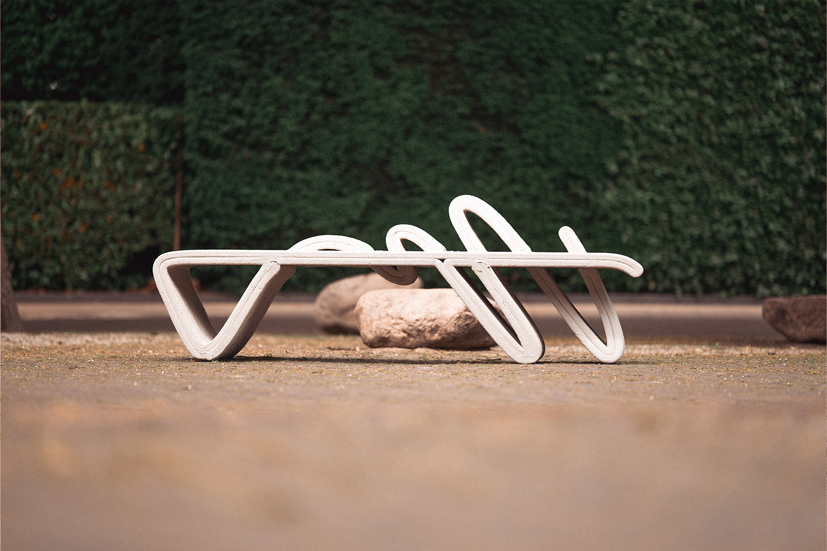 White curved concrete bench with organic shapes for urban printing projects
