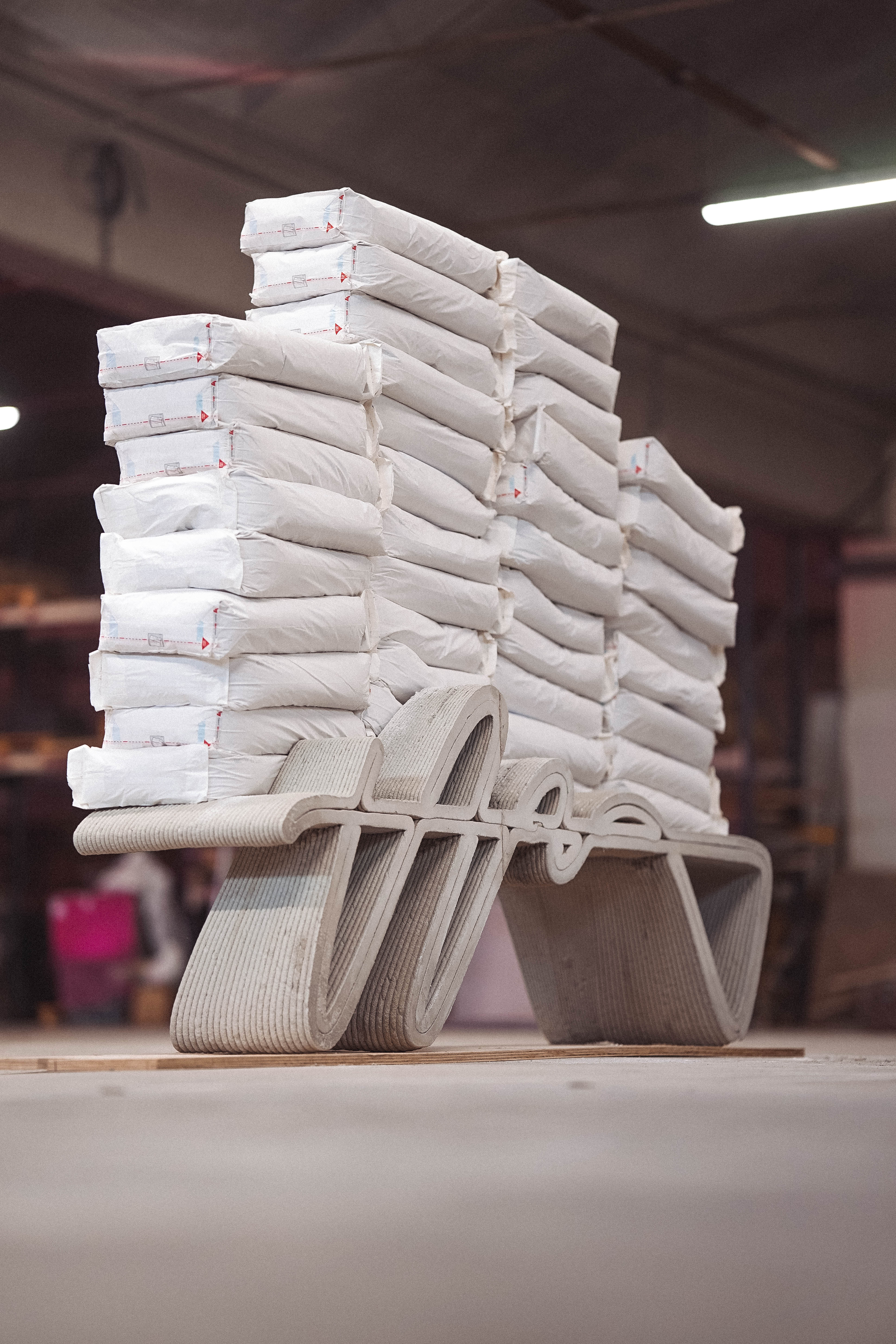 Stacked concrete printing bags on sculptural concrete display stand