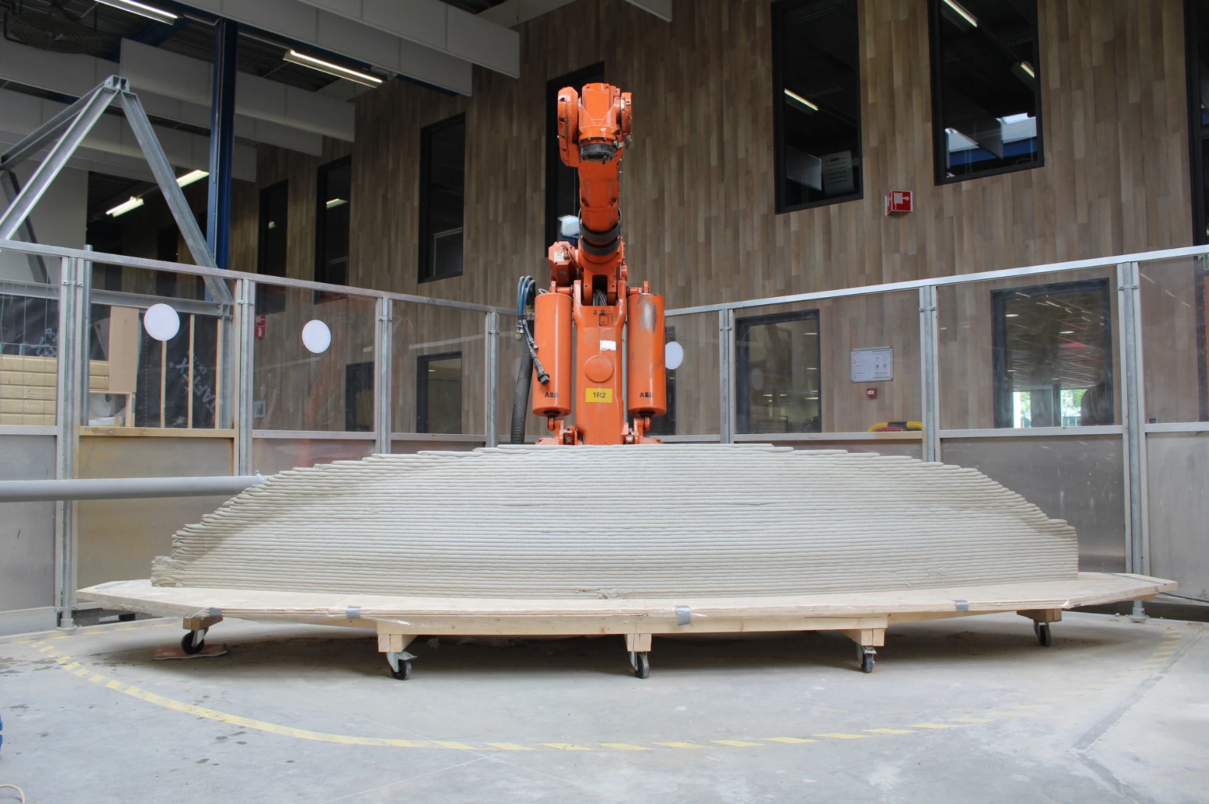 Orange robotic arm 3D printing concrete structure for innovative construction projects