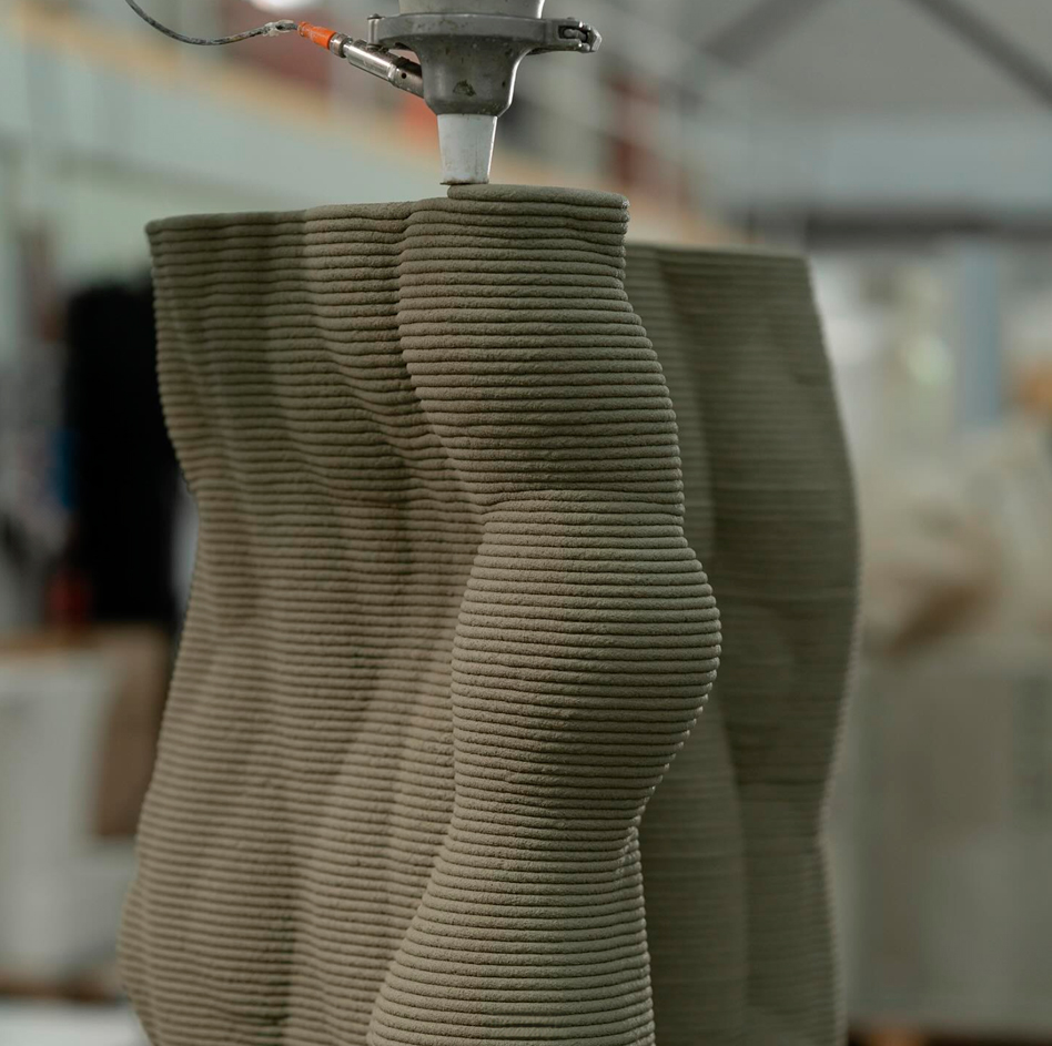 3D printer creating layered concrete design with precise robotic arm
