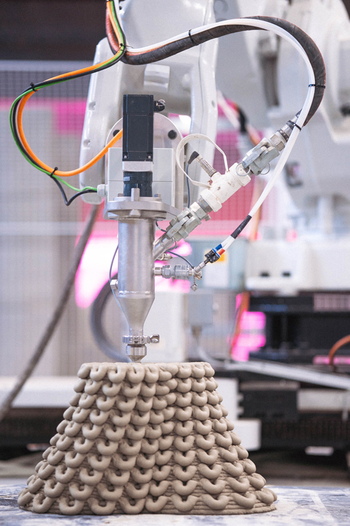 3D concrete printing project with robotic arm creating layered sculptural object