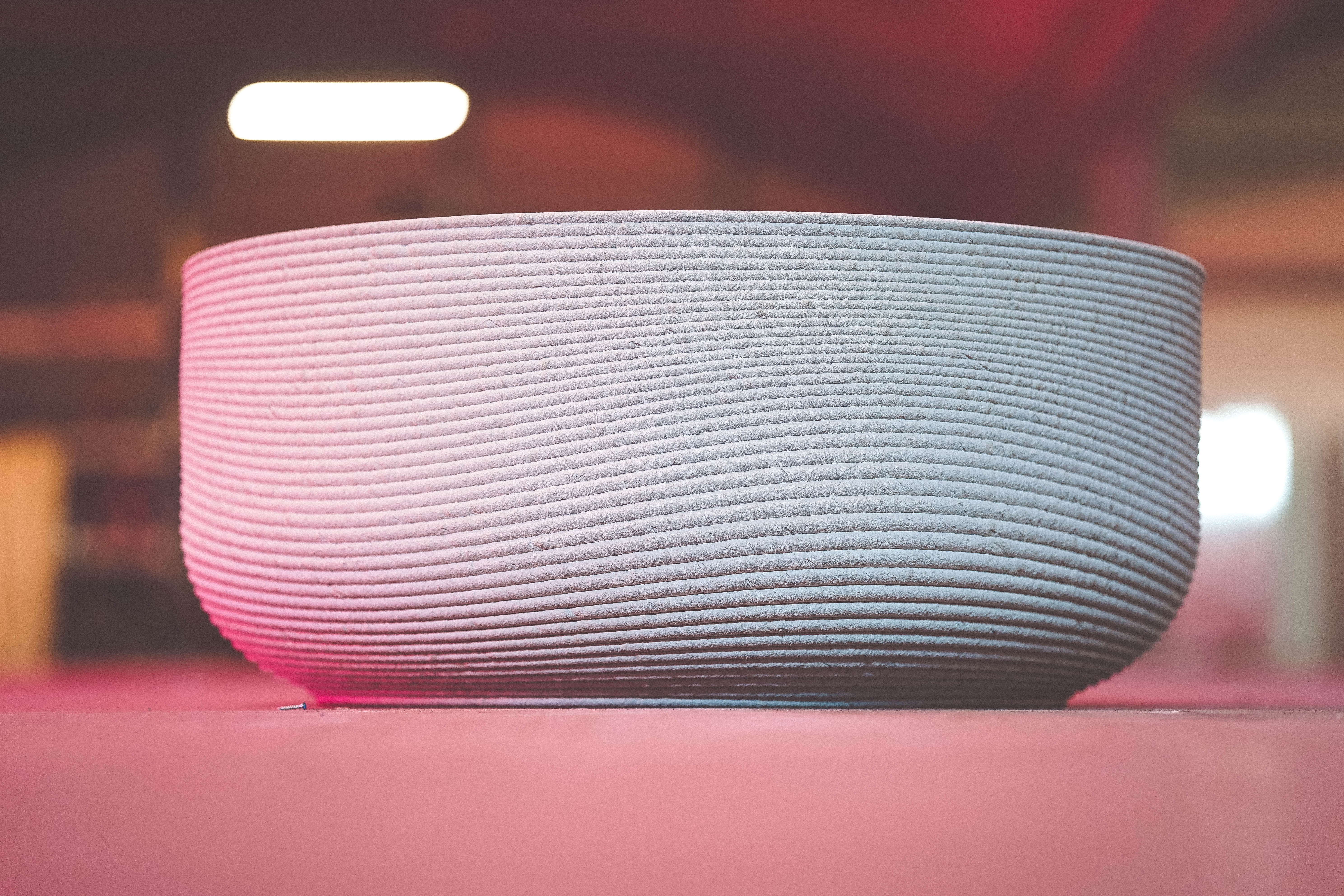 Ceramic bowl with gradient pink and blue ribbed texture on pink surface