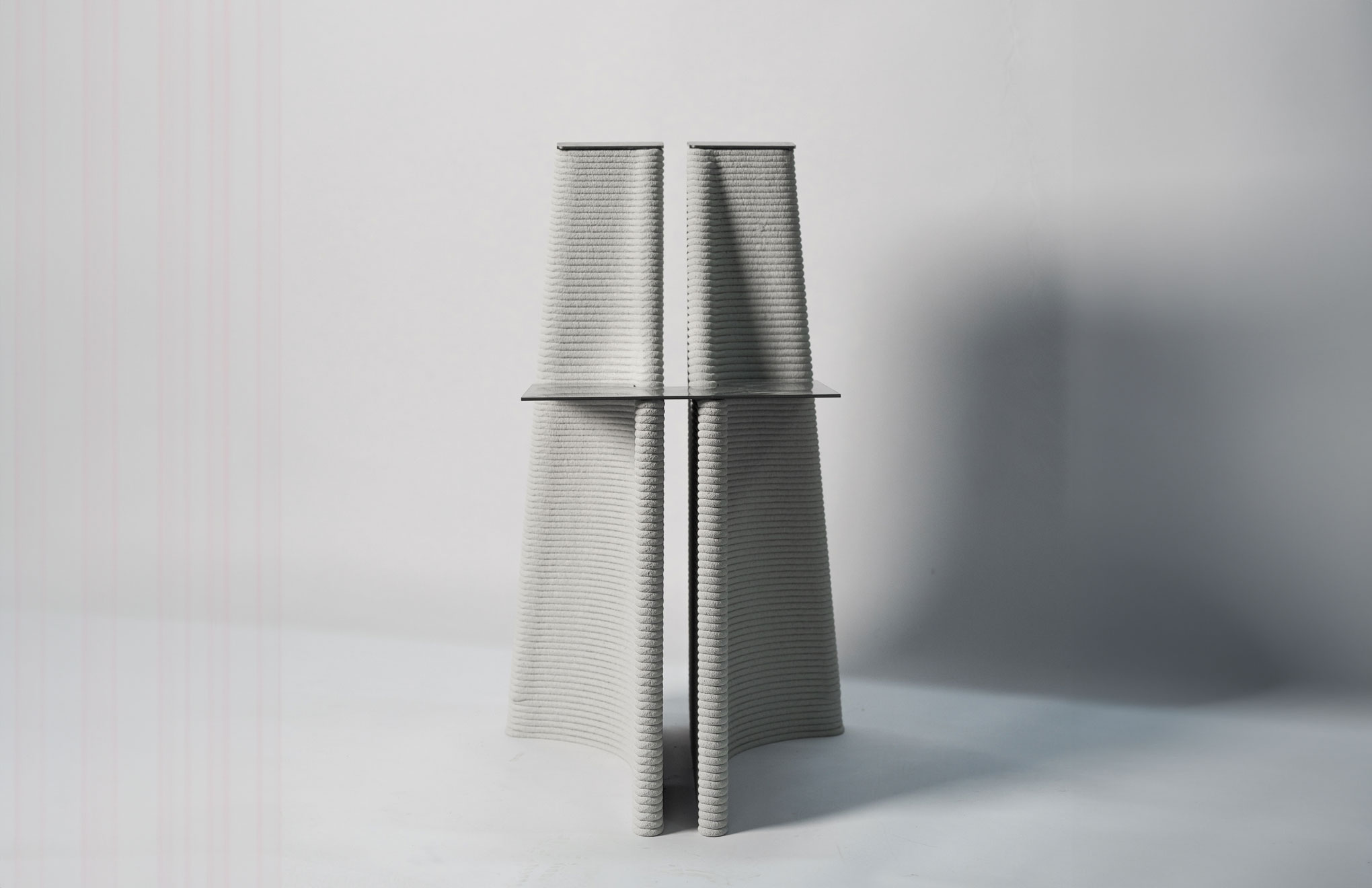 Two textured gray columns connected by a horizontal platform