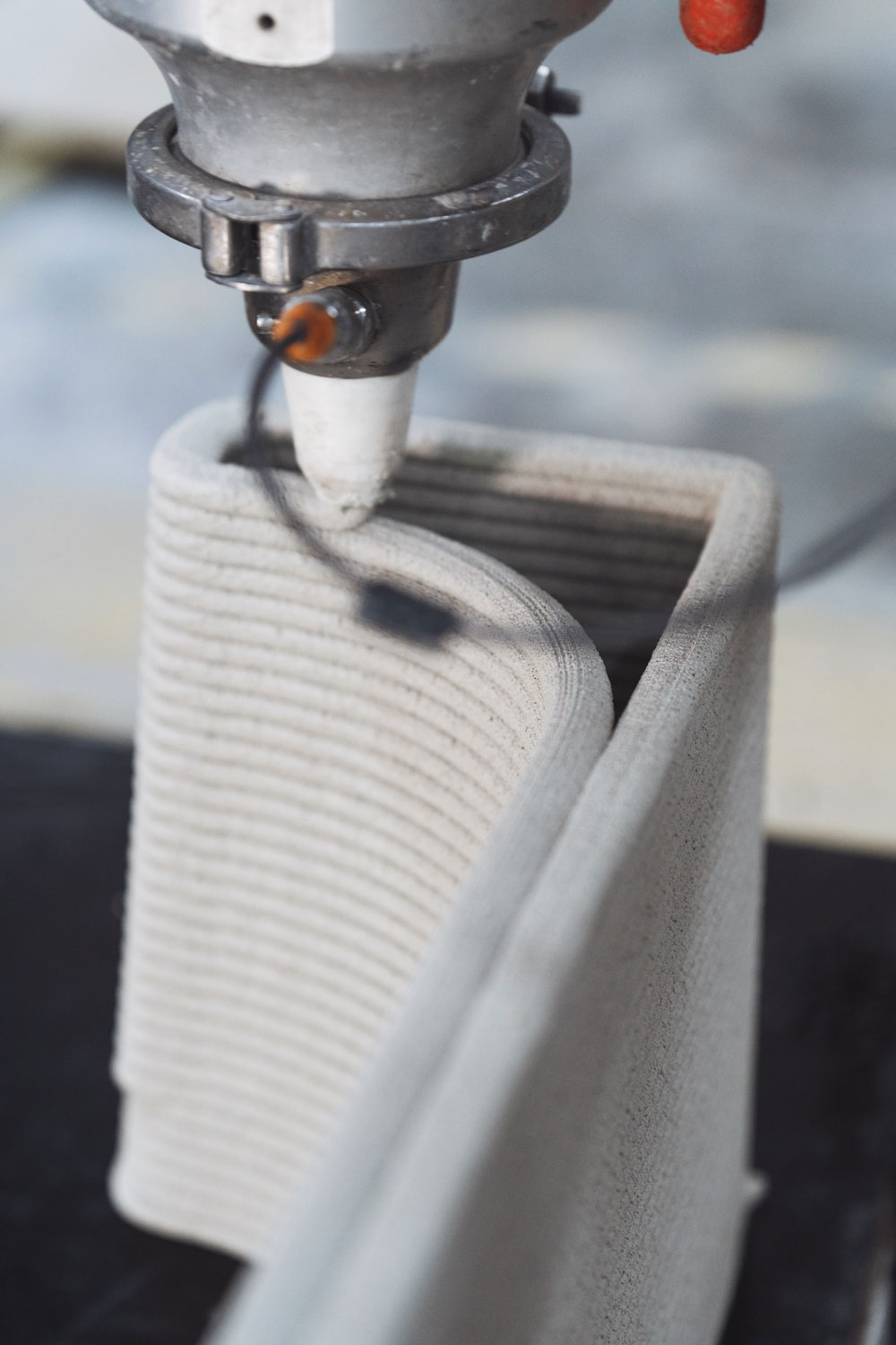 3D printer nozzle creating a white layered object close-up