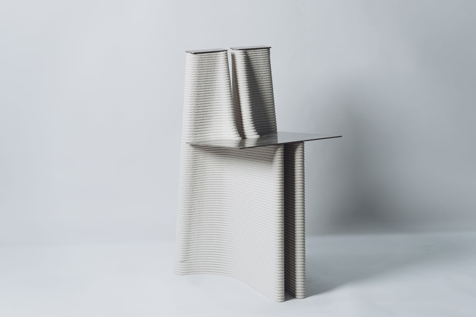 Minimalist sculptural design with ribbed white form and metal shelf