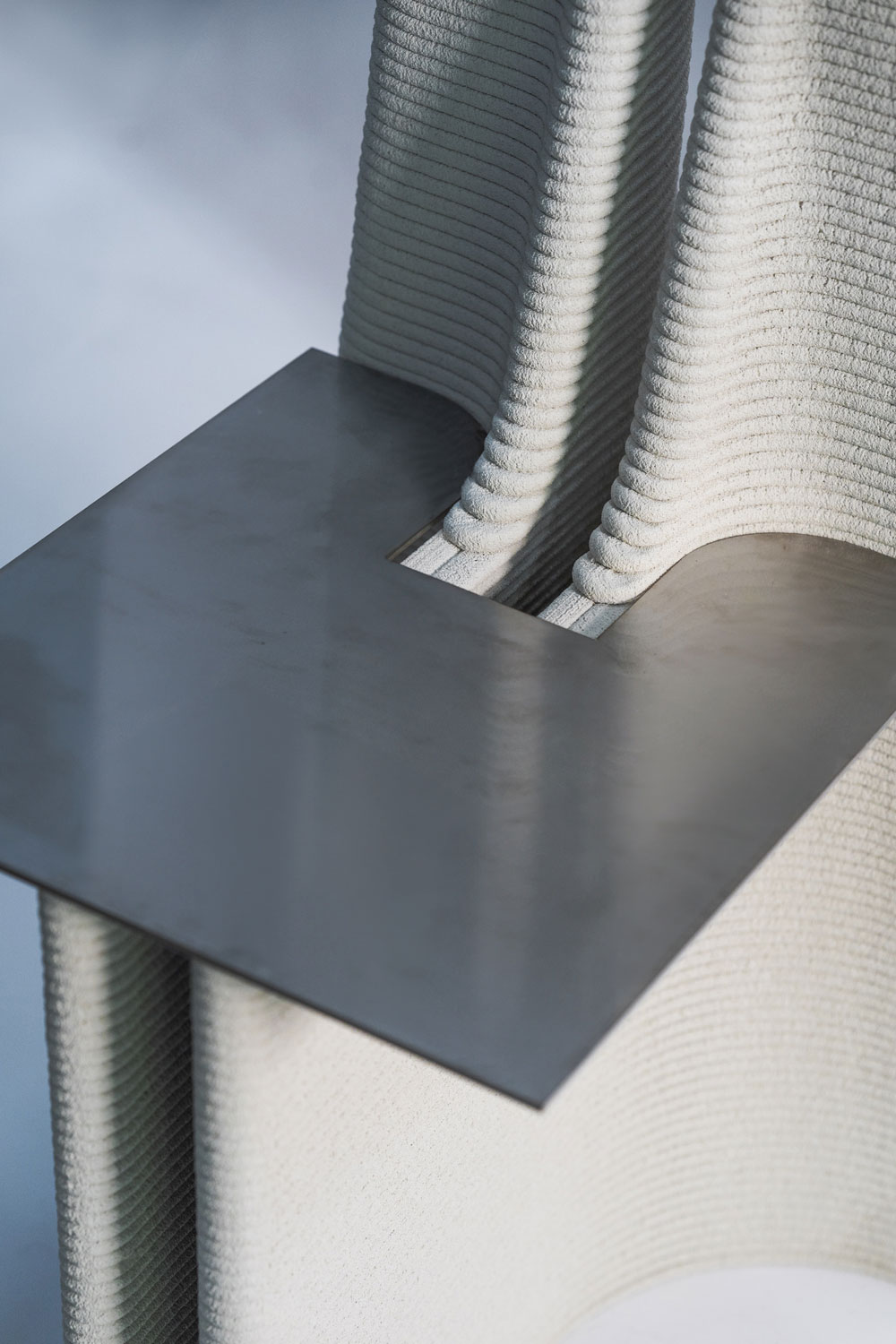 Textured textile and metal surface creating geometric abstract architectural composition