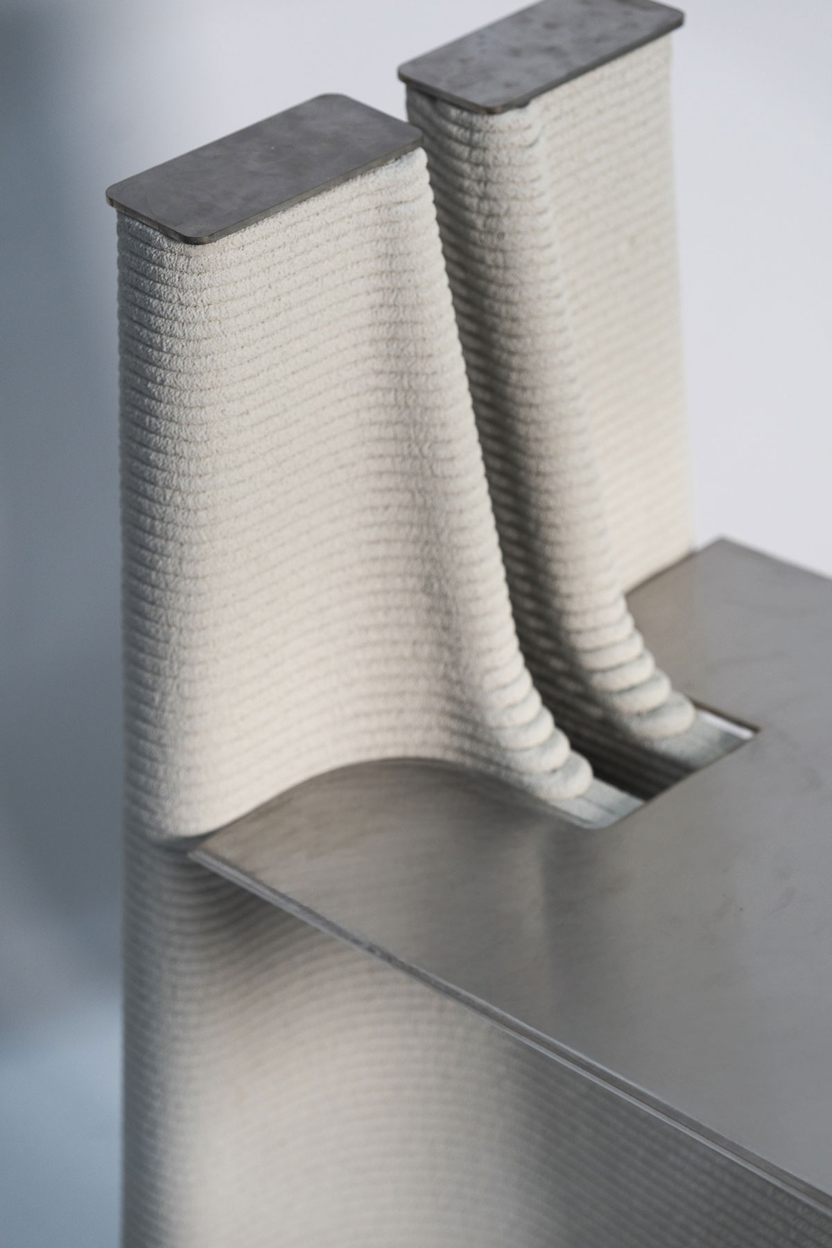 Two white textured towels with metal base in minimalist design