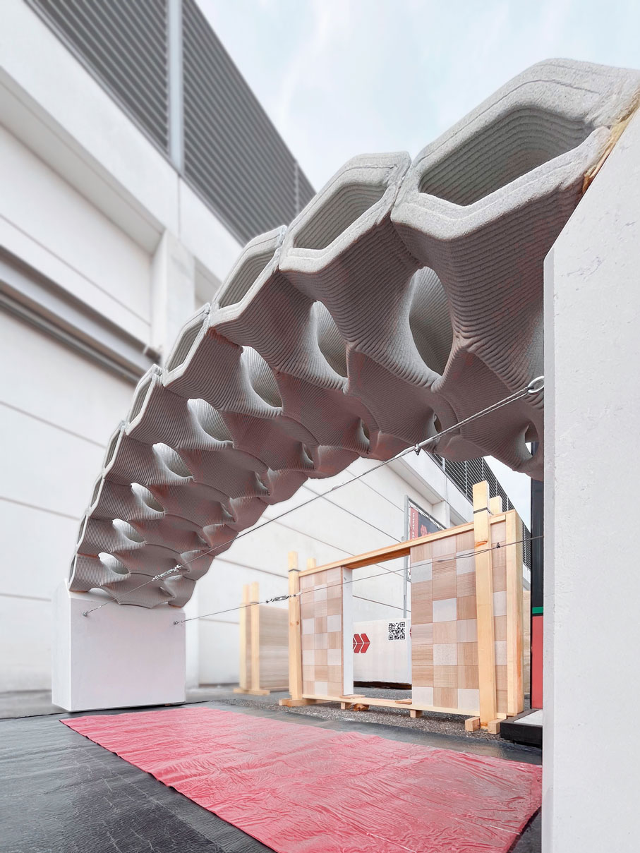 Sculptural white curved architectural structure over red floor and wooden crates