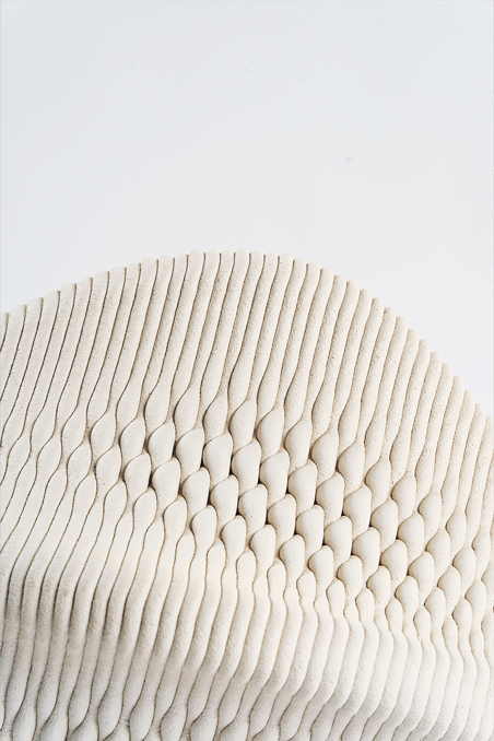 3D printed concrete sculpture with wavy textured pattern and organic curves