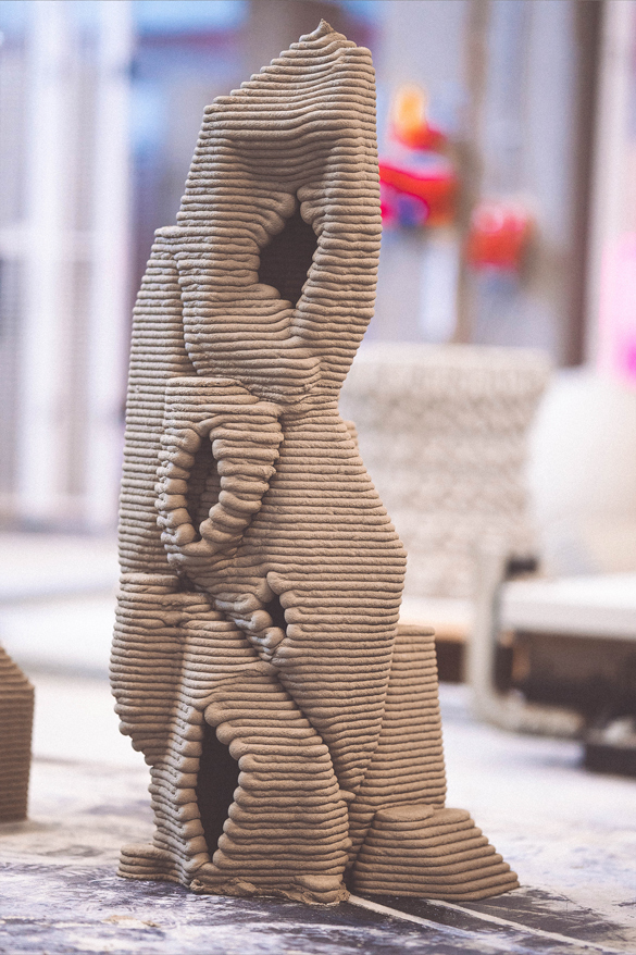 3D concrete printing creating intricate sculptural project with layered organic form