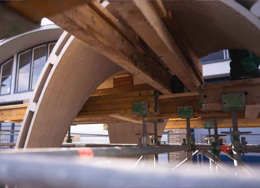 3D concrete printing project with curved architectural structure and support clamps