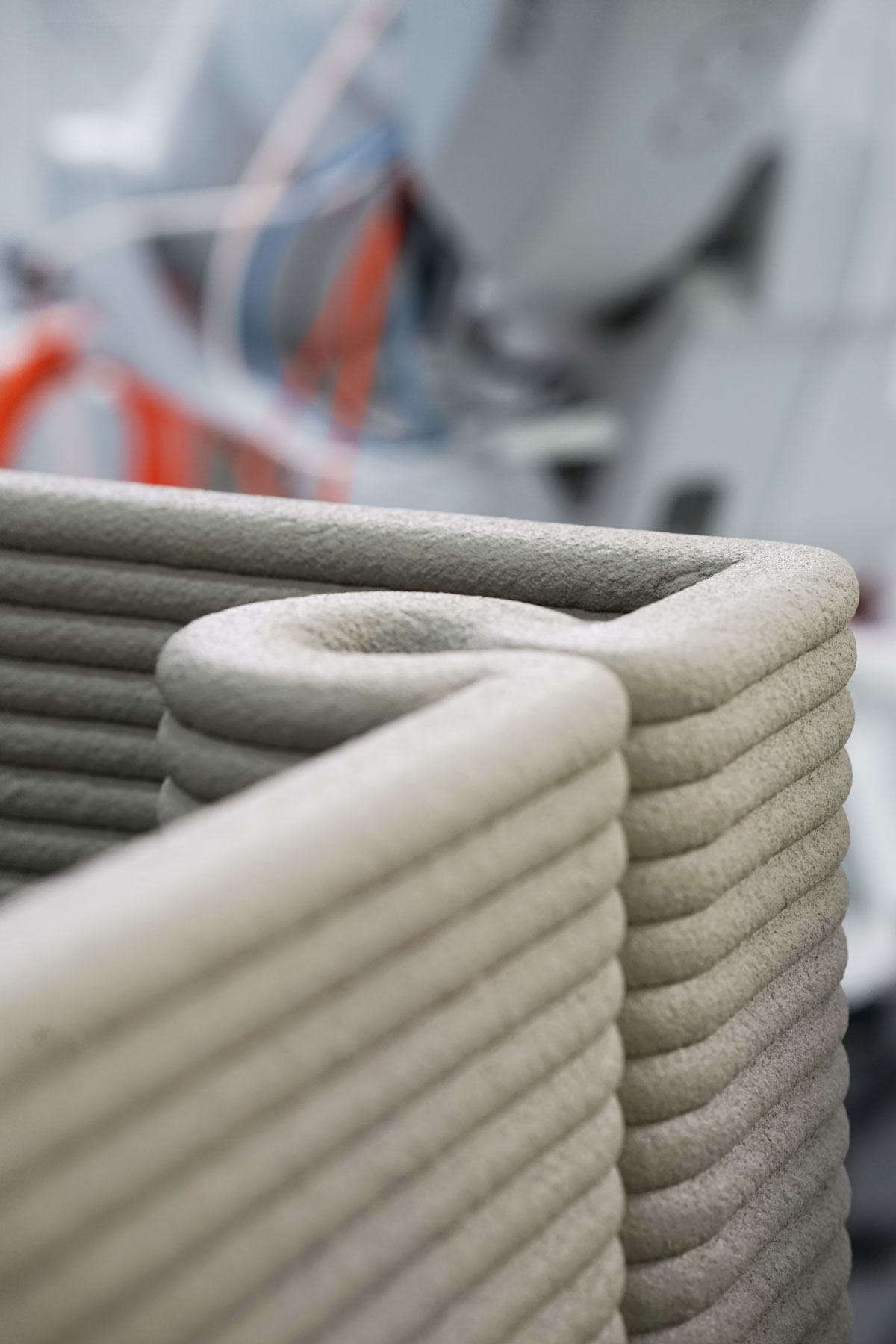 3D concrete printing creating layered architectural prototype with textured design