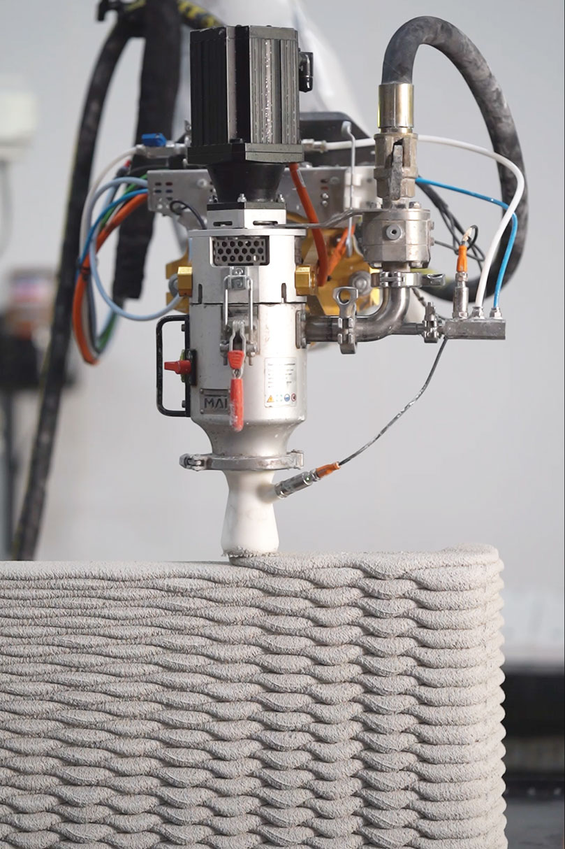 3D concrete printing robot creating layered architectural structure