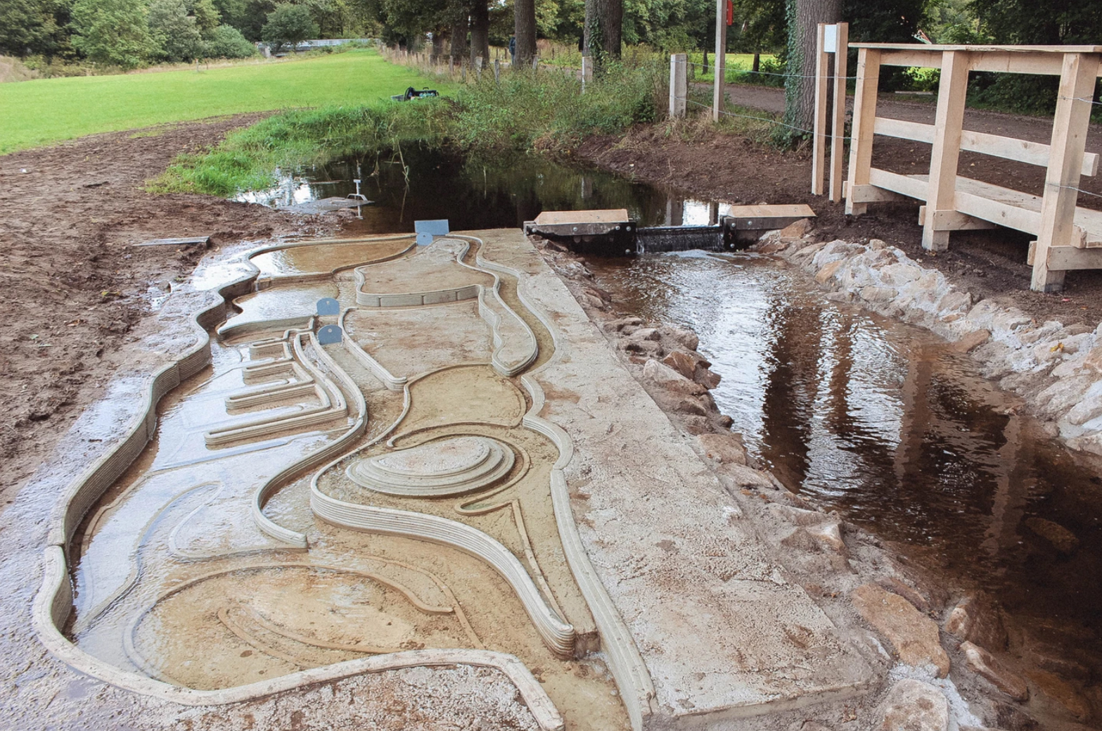3D concrete printing project creating intricate landscape model near water