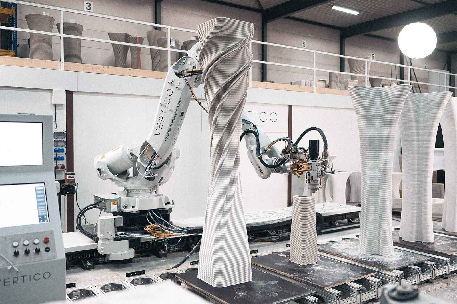 3D concrete printing robot creating tall, textured architectural structures