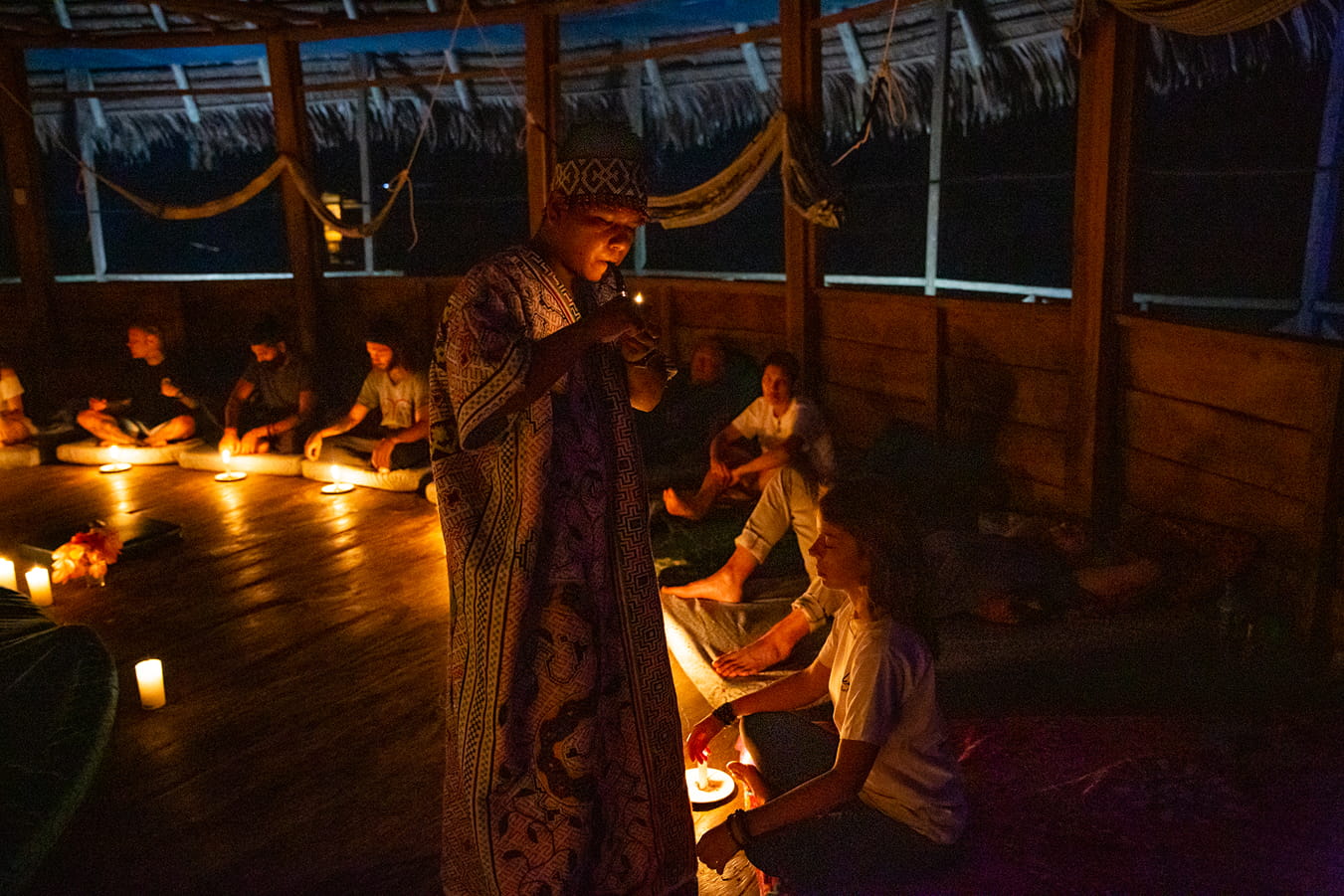 A dark ayahuasca ceremony with a Shipibo shaman smoking a pipe. 