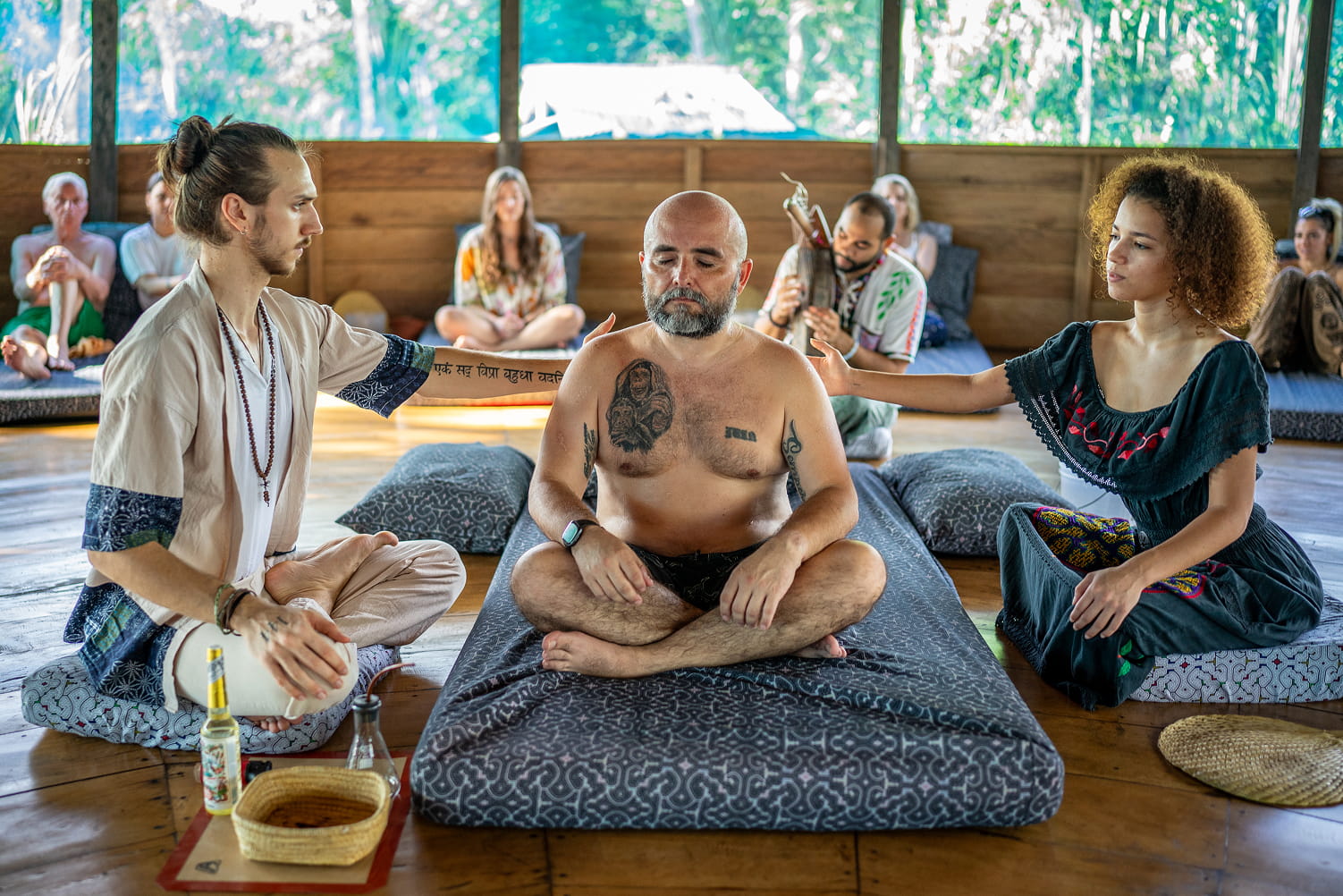 A gentleman sitting on a mat inside of a traditional Sapo ceremony 