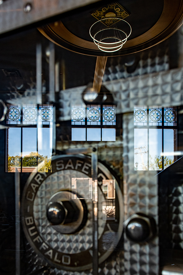 The original Buffalo bank vault door at The Caz, seen through glass