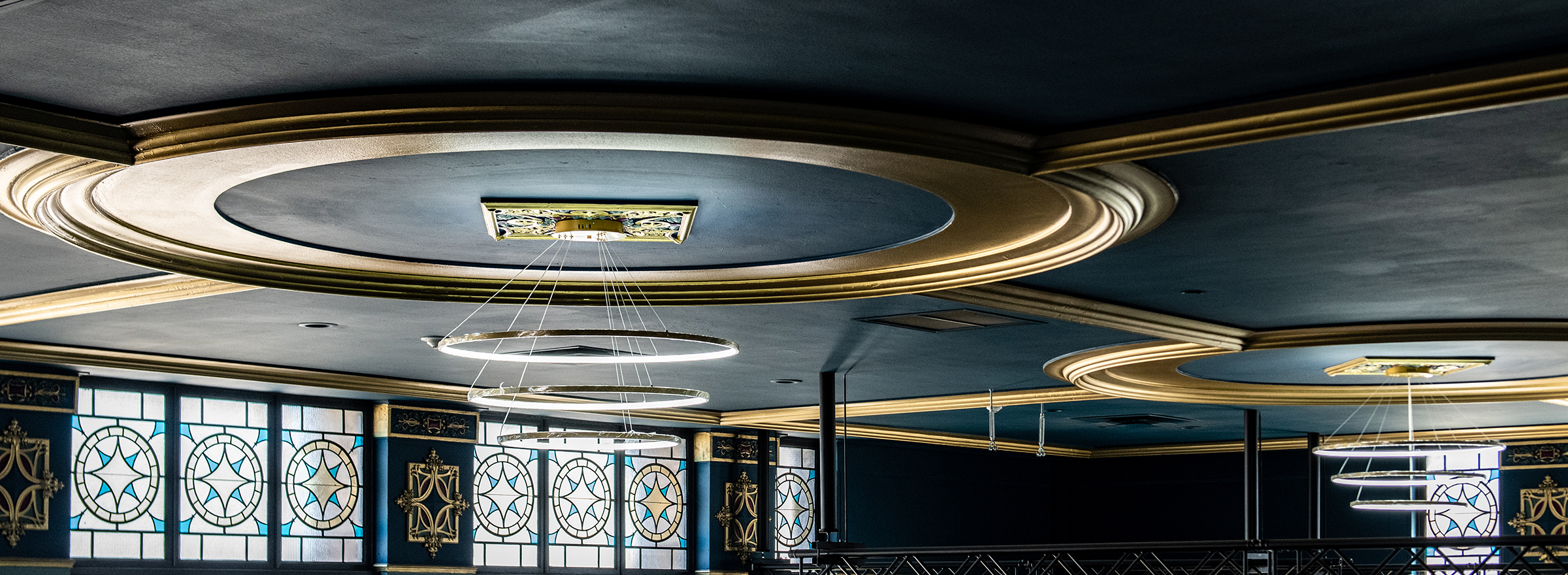 The Caz mezzanine with gold-trimmed ceiling medallions and stained glass windows